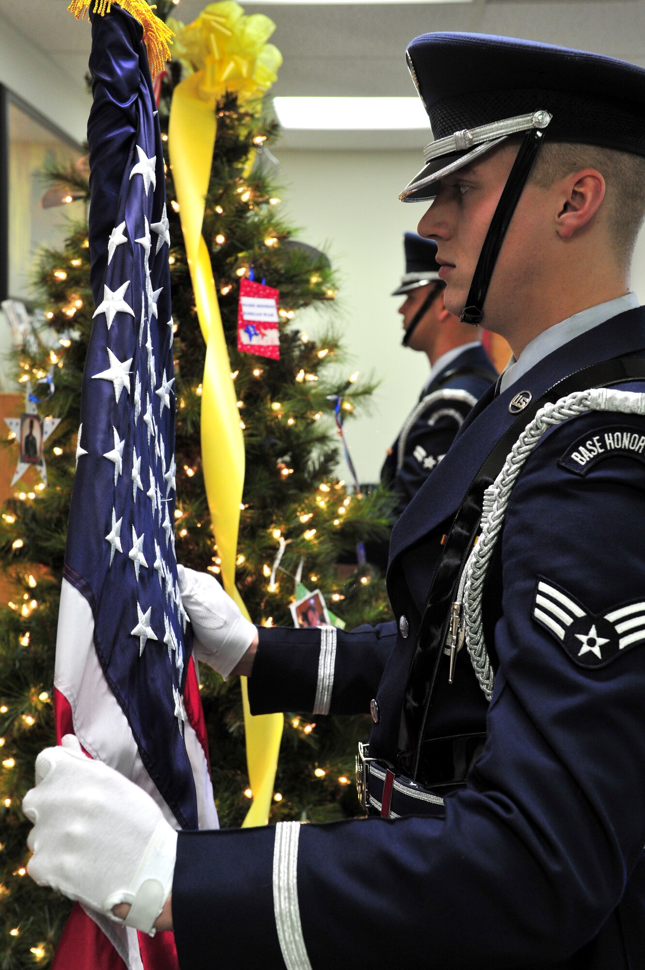 A member of the Cannon Air Force Base Honor Guard straightens the American Flag at the being of a Heroes' Tree Dedication ceremony at the base library, Nov. 14, 2010. Our Heroes' Tree is a community outreach program co-founded in 2005 by Stephanie Pickup, author of The Soldiers' Tree, and Marlene Lee, author of The Hero in My Pocket. This program promotes awareness of the service and sacrifice of U.S. service members and their families. (U.S. Air Force photo by Tech Sgt. Josef Cole)(RELEASED) 