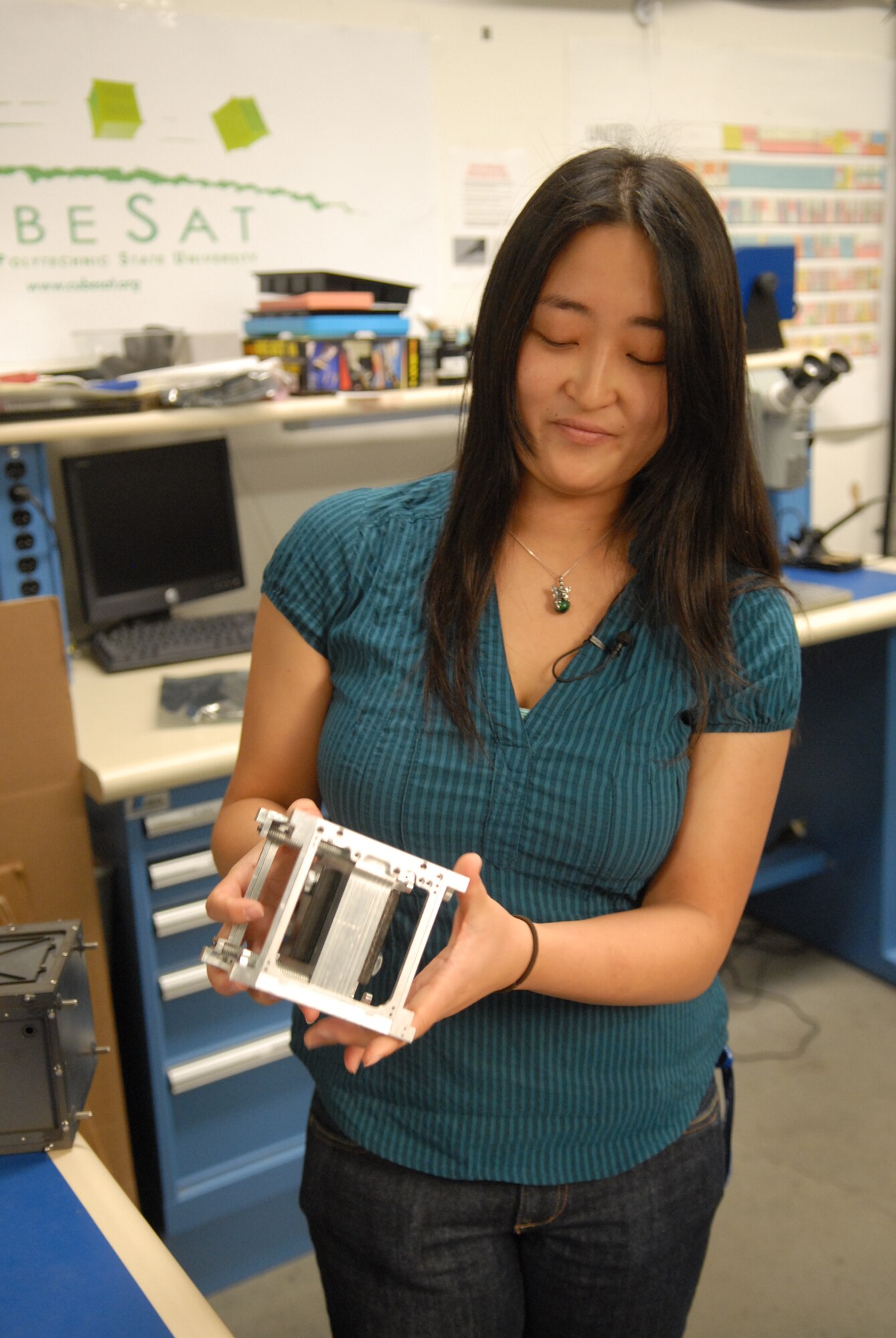 SAN LUIS OBISPO, Calif. – Stephanie Wong, an aerospace engineering student at California Polytechnic State University, displays the research satellite, or CubeSat, frame she designed as her senior project. Up to three CubeSats fit into a Poly Picosatellite Orbital Deployer, or PPOD, container. The PPOD and CubeSat Project were developed by California Polytechnic State University and Stanford University’s Space Systems Development Lab for use on NASA’s Educational Launch of Nanosatellite, or ELaNa missions. Each CubeSat measures about four inches cubed; about the same volume as a quart. The CubeSats weigh about 2.2 pounds, must conform to standard aerospace materials and must operate without propulsion. (U.S. Air Force photo/Jerry E. Clemens, Jr.)