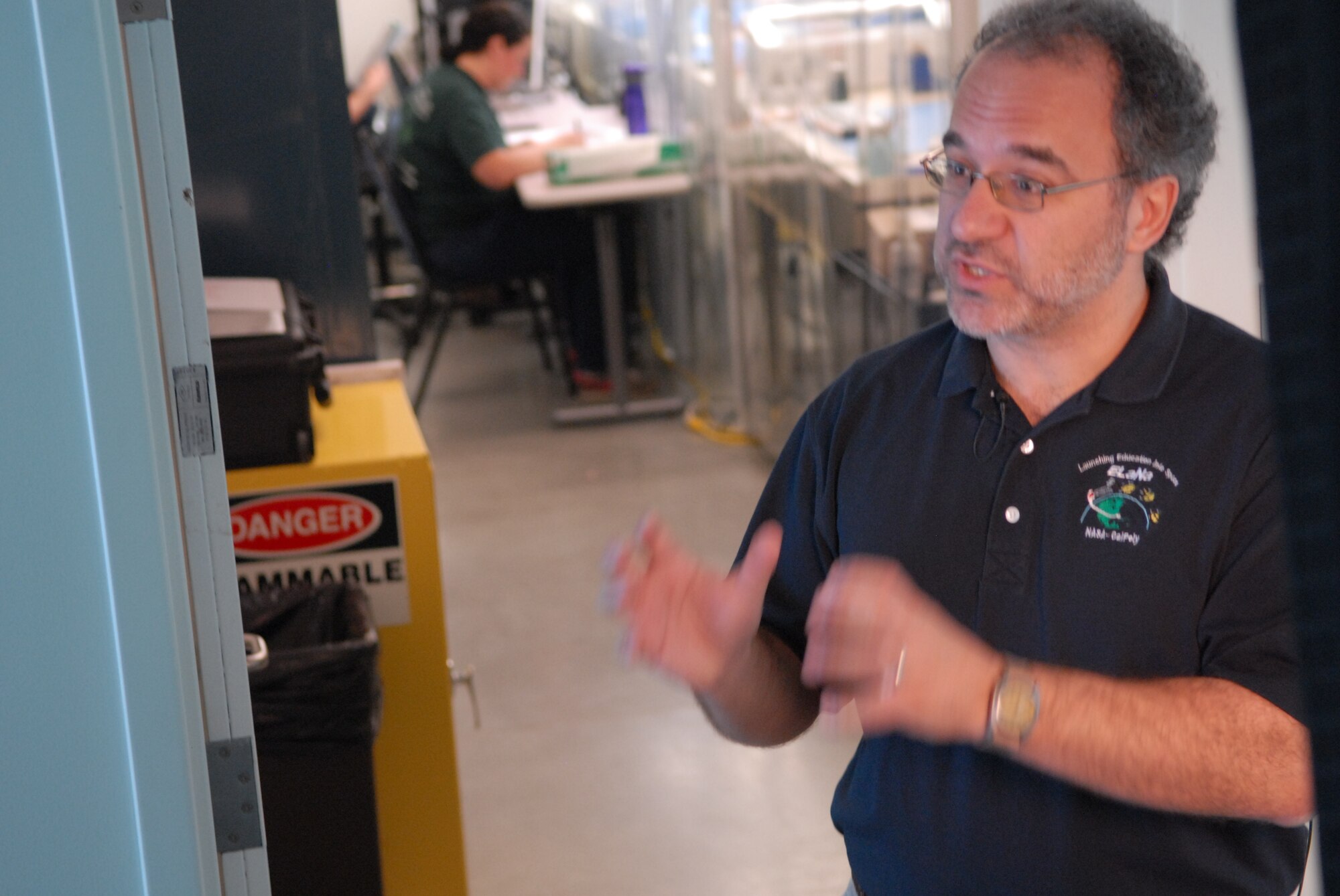 SAN LUIS OBISPO, Calif. – Jordi Puig-Suari, Cal Poly professor of aerospace engineering, explains the value in students gaining hands-on experience designing, developing and building mini research satellites, or CubeSats, and the Poly Picosatellite Orbital Deployer, or PPOD, container. The PPOD and CubeSat Project were developed by California Polytechnic State University and Stanford University’s Space Systems Development Lab for use on NASA’s Educational Launch of Nanosatellite, or ELaNa missions. Each CubeSat measures about four inches cubed; about the same volume as a quart. The CubeSats weigh about 2.2 pounds, must conform to standard aerospace materials and must operate without propulsion. (U.S. Air Force photo/Jerry E. Clemens, Jr.)