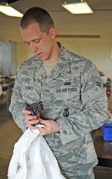 Airman 1st Class Brian Turney, 28th Security Forces Squadron patrolman from Ellsworth Air Force Base, S.D., cleans part of his 9mm handgun during Global Strike Challenge Nov. 16 at Barksdale AFB, La. The challenge showcases the world's premier bomber and Intercontinental Ballistic Missile force. The events foster esprit de corps through competition and teamwork. (U.S. Air Force photo/Airman 1st Class Sean Martin)(Released)