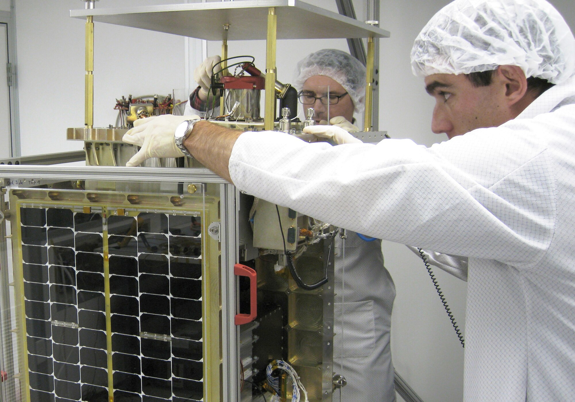 Pat O'Grady from InStar Engineering and Eric Ehrbar from Busek Inc. confirm FalconSAT-5's fit check with its main payload, the Space Plasma Characterization Source, Sept. 28, 2009, at the U.S. Air Force Academy in Colorado Springs, Colo. FalconSAT-5 is an $11-million program sponsored by the Air Force Research Laboratory, headquartered at Wright-Patterson Air Force Base, Ohio. It is scheduled to launch from Kodiak Launch Complex, Alaska, Nov. 19, 2010. (U.S. Air Force photo/Maj. Steve Hart)