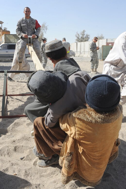 Tech. Sgt. Michael Zigarelli plays with a group of Afghan children on a seesaw Nov. 13, 2010, at Kandahar Airfield, Afghanistan. Sergeant Zigarelli is a patrolman with the International Security Assistance Force Military Police. (U.S. Air Force photo/Tech. Sgt. Chad Chisholm)