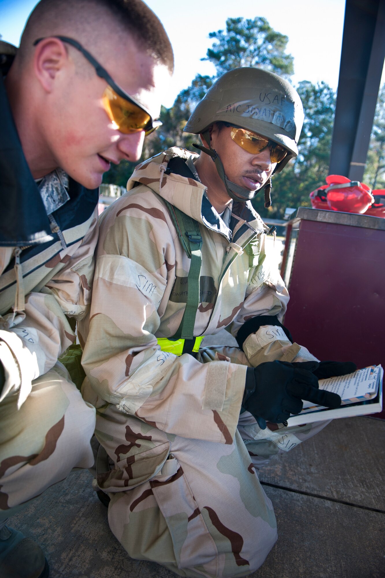 MOODY AIR FORCE BASE, Ga. -- Airmen 1st Class Skylar Young (left) and Jonathan Gaillard, 23rd Equipment Maintenance Squadron munitions crew members, refer to an Airman's Manual for the steps on how to treat an arm injury during a Phase II Operational Readiness Exercise Nov. 17. Exercises are designed to test the base's ability to conduct missions in a deployed environment but also serve as a time to train Airmen on self-aid and buddy care techniques. (U.S. Air Force photo/Senior Airman Jamal D. Sutter)(RELEASED)