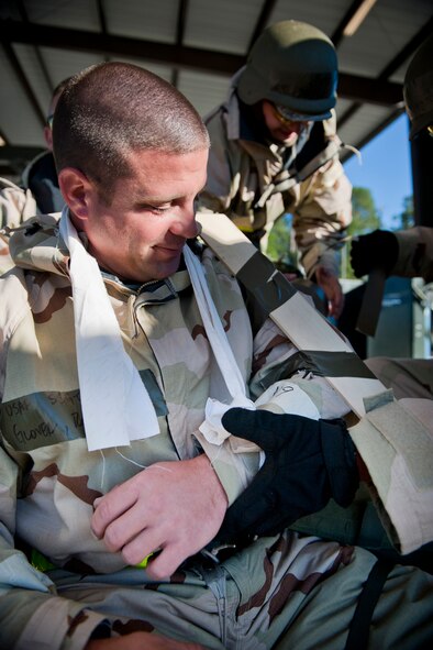MOODY AIR FORCE BASE, Ga. -- Staff Sgt. Rodney Glover, 23rd Equipment Maintenance Squadron conventional maintenance crew member, watches his co-workers apply a splint to his simulated arm injury during a Phase II Operational Readiness Exercise Nov. 17. The crew members were tasked by an exercise evaluation team member to demonstrate their self-aid and buddy care skills. (U.S. Air Force photo/Senior Airman Jamal D. Sutter)(RELEASED)