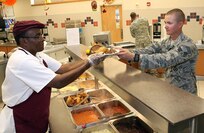 Gary Daniels serves lunch to Senior Airman Joseph Swartout, a student in the military working dog handler's course, at the Lackland Training Annex dining facility Nov. 10. The 802nd Force Support Squadron was recently named the winner of the Air Education and Training Command 2011 Hennessy Trophy Award in the multiple dining facility category. The award recognizes base food service operations, improving the morale of food service personnel and promoting a better Air Force Food Service Program. The squadron advances to Air Force level competition. (U.S. Air Force photo/Antonio Morano)
