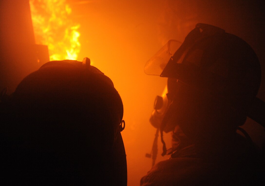 ANDREWS AIR FORCE BASE, Md. -- Col. Ken Rizer, 11th Wing/Joint Base Andrews commander, enters a burning building with 11th Civil Engineer Squadron firefighters during live fire training at Joint Base Andrews Nov. 17.  Firefighters from the 11 CES regularly perform live fire training to stay proficient in their life saving skills. (U.S. Air Force photo by Senior Airman Melissa V. Brownstein)