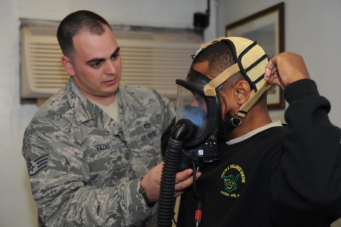 ANDREWS AIR FORCE BASE, Md. -- Staff Sgt. Daniel Fazio, 11th Civil Engineer Squadron firefighter, performs a mask fit test on Chief Master Sgt Anthony Brinkley, 11th Wing/Joint Base Andrews command chief, before Chief Brinkley’s  live fire training at Joint Base Andrews Nov. 17. The fit test is made up of eight breathing tests performed in a mask to ensure proper seal and size. (U.S. Air Force photo by Senior Airman Melissa V. Brownstein)