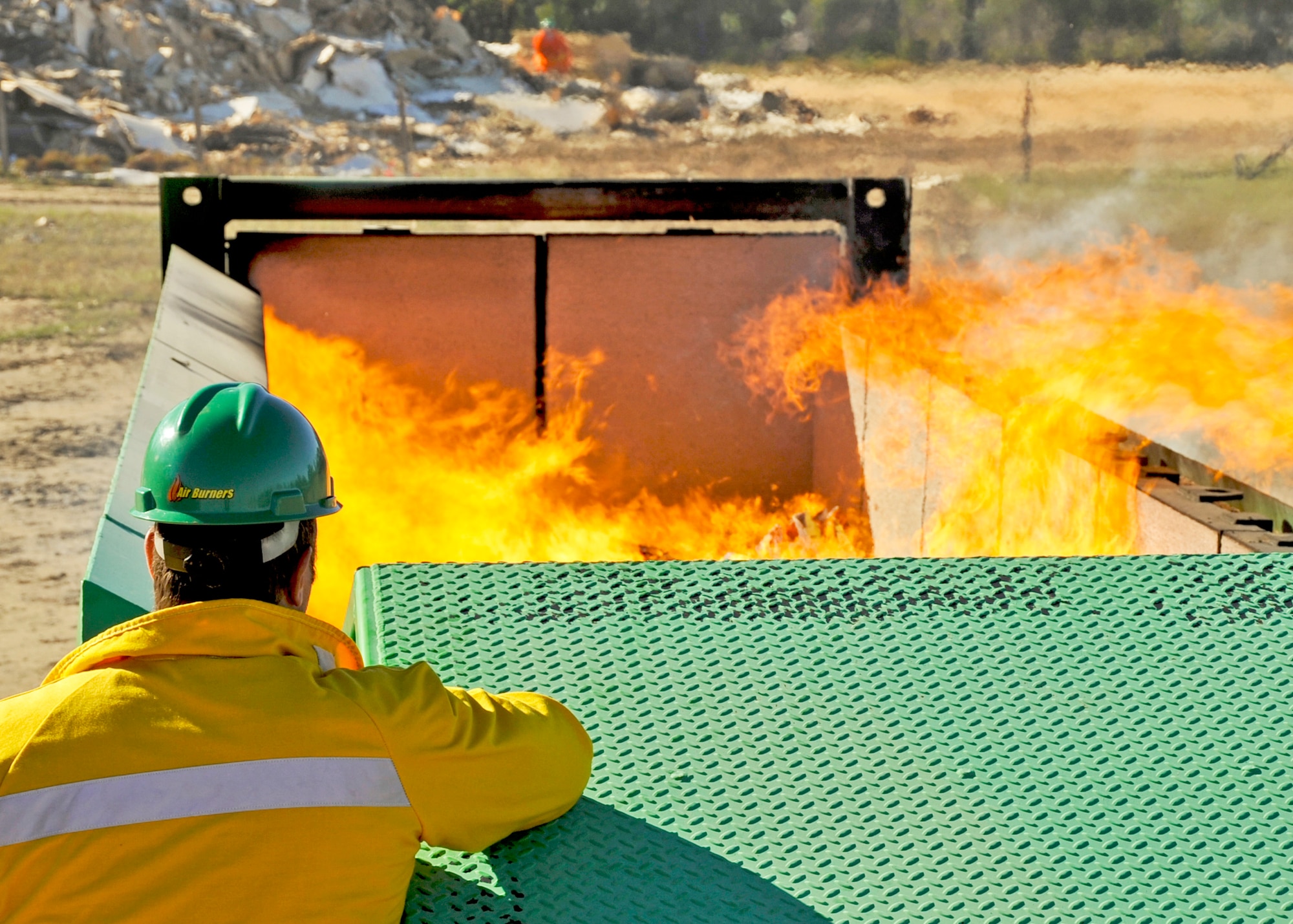 Matt O'Conner monitors the flame height of the 46th Test Wing's new air curtain incinerator Oct. 31, 2010, at Eglin Air Force Base, Fla. Air Burners personnel were on hand during the burner's test run to ensure the new equipment worked properly and trained base personnel on how to use it. Mr. O'Conner is a sales manager with Air Burners. (U.S. Air Force photo/Samuel King Jr.)