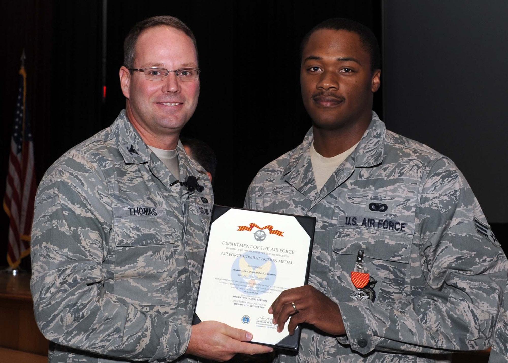 ALTUS AIR FORCE BASE, Okla.--Col. Ty Thomas, 97th Air Mobility Wing commander, presents Airman 1st Class Brandon J. Brown, 97th Security Forces Squadron, with the Air Force Combat Action Medal Nov. 10 for the bravery he and 3 other Airmen showed when their vehicle came under attack during their deployment to Joint Base Balad, Iraq. (U.S. Air Force photo/Senior Airman Leandra D. Stepp/Released 97th Air Mobility Wing Public Affairs) 