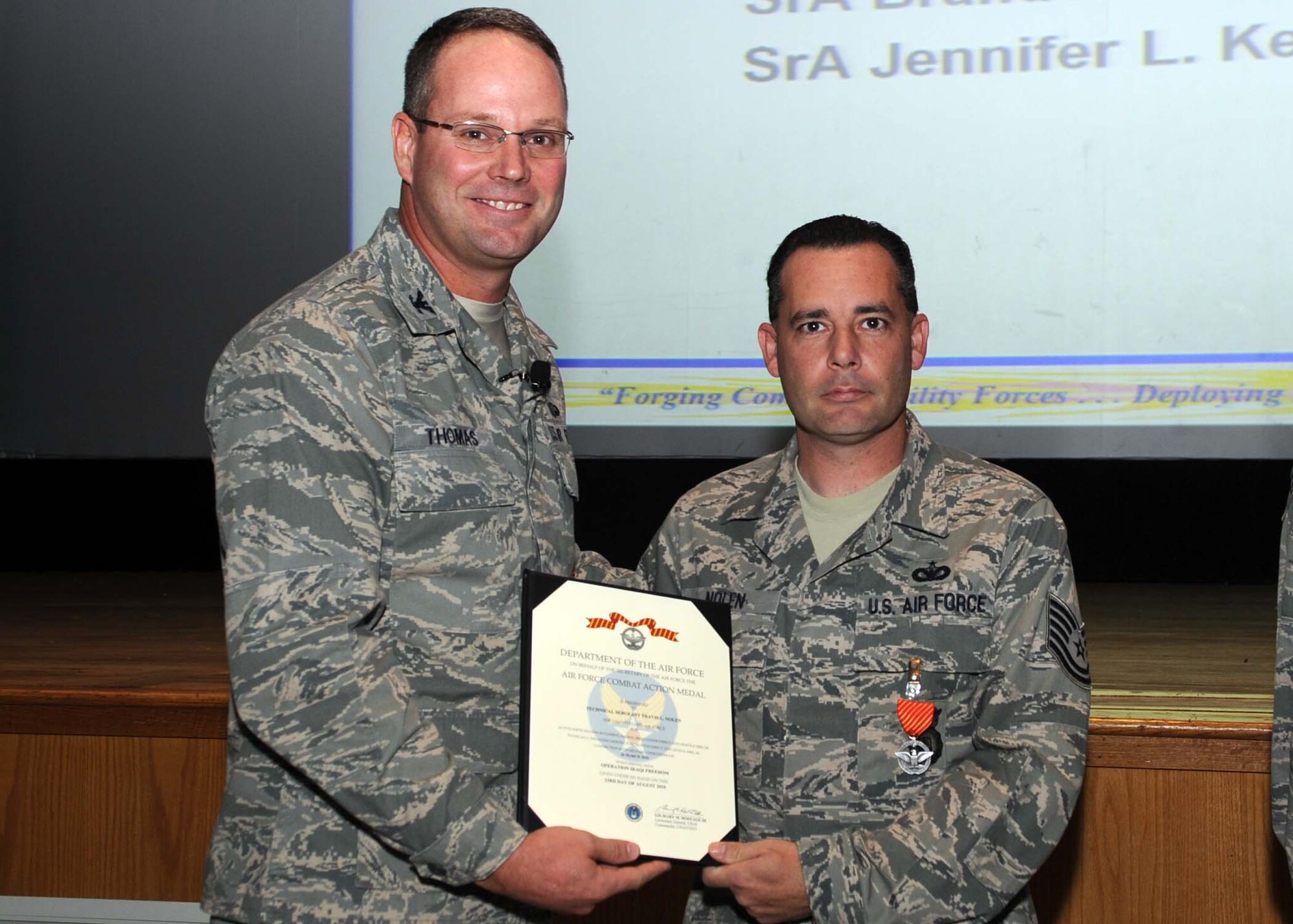 ALTUS AIR FORCE BASE, Okla.--Col. Ty Thomas, 97th Air Mobility Wing commander, presents Tech. Sgt. Travis L. Nolan, 97th Security Forces Squadron, with the Air Force Combat Action Medal Nov. 10 for the bravery he and 3 other Airmen showed when their vehicle came under attack during their deployment to Joint Base Balad, Iraq. (U.S. Air Force photo/Senior Airman Leandra D. Stepp/Released 97th Air Mobility Wing Public Affairs) 