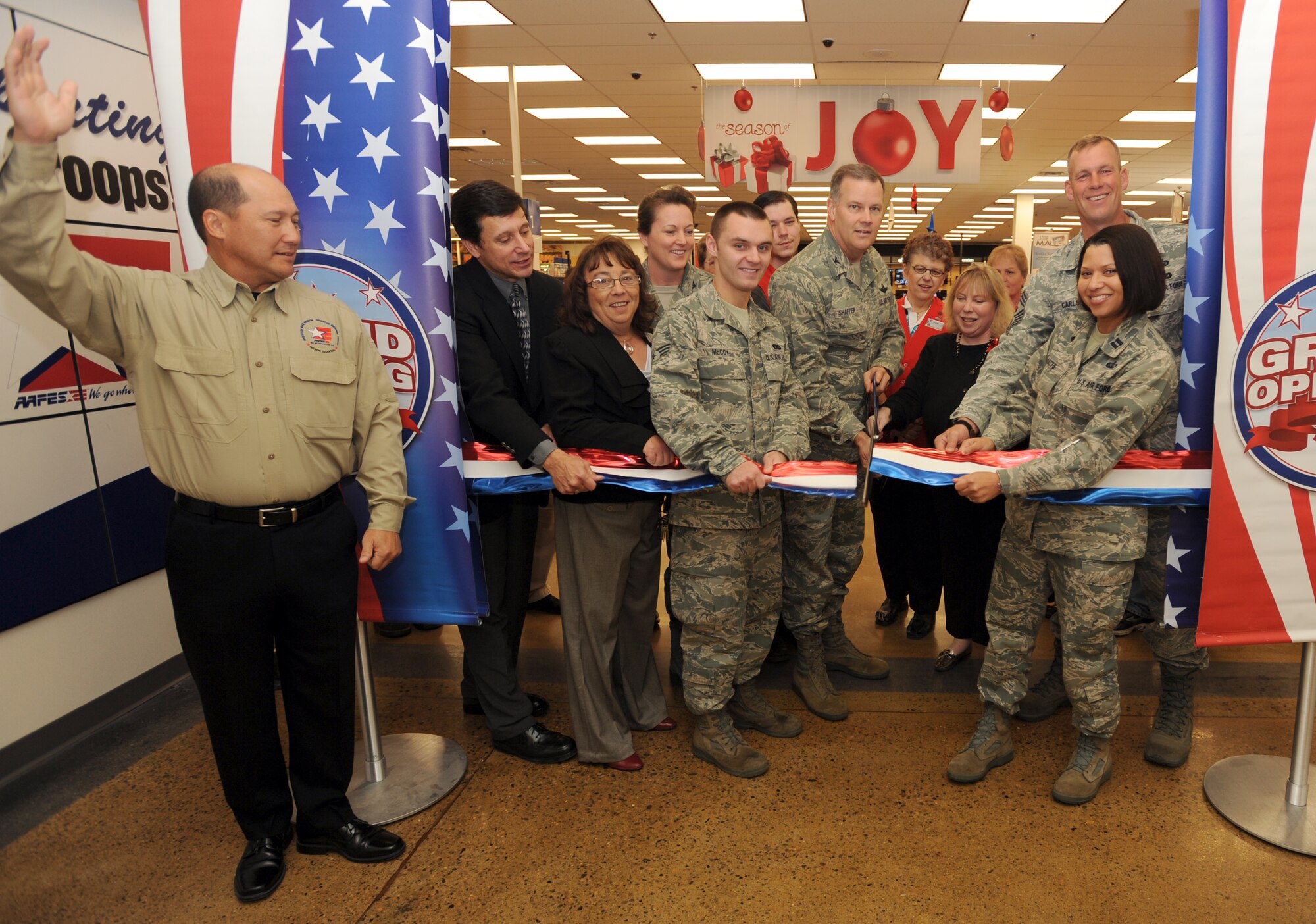 Employees from the Army and Air Force Exchange Services along with Patricia Fields (third in from the left), store manager of the Grand Forks Air Force Base Base Exchange, Col. Tammy Knierim (fourth from the left), 319th Mission Support Group commander, Senior Airman James McCoy (fifth from left), 319th Logistics Readiness Squadron, Col. Don Shaffer (center), 319th Air Refueling Wing commander, Kathi Zeller (seventh from left), general manager of Minot AFB BX, Chief Master Sgt. David Carlson (eighth from left), 319th ARW command chief, and Capt. Angela Batts, 319th Force Support Squadron, cut the ribbon to officially re-open the BX Nov. 17, after nine months of construction and renovations. AFFES spent a total of $4 million on the project. (U.S. Air Force photo by Staff Sgt. Suellyn Nuckolls)