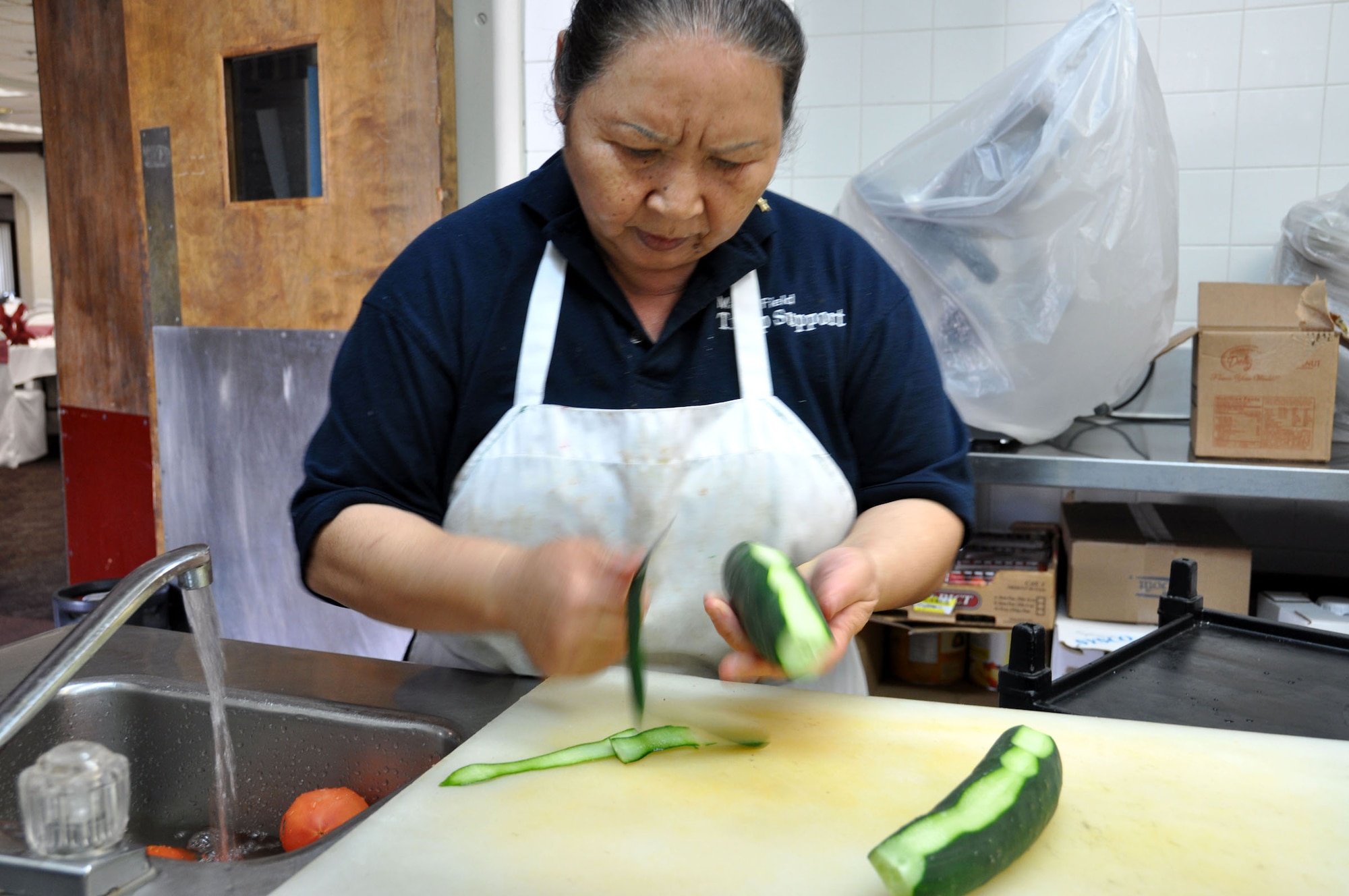 Nam Dodson peels a cucumber in the Hap Arnold Club kitchen Oct. 16, 2010.  During unit training assembly weekends, the club staff prepares food for troop feeding and conference center events.  (U.S. Air Force photo/Linda Welz)