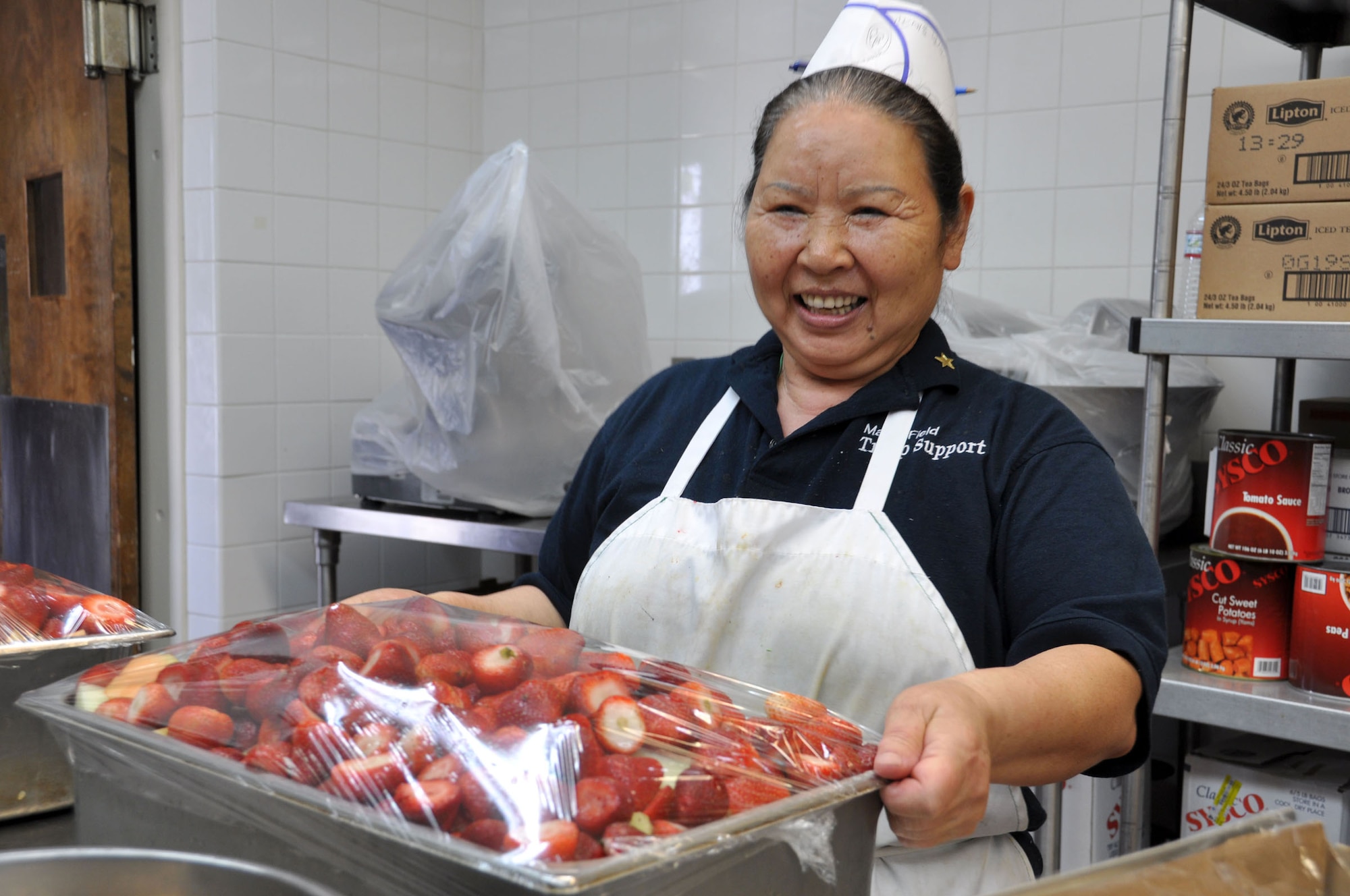Nam Dodson carries a tray of strawberries in the Hap Arnold Club kitchen Oct. 16, 2010.  During unit training assembly weekends, the club staff prepares food for troop feeding and conference center events.  (U.S. Air Force photo/Linda Welz)