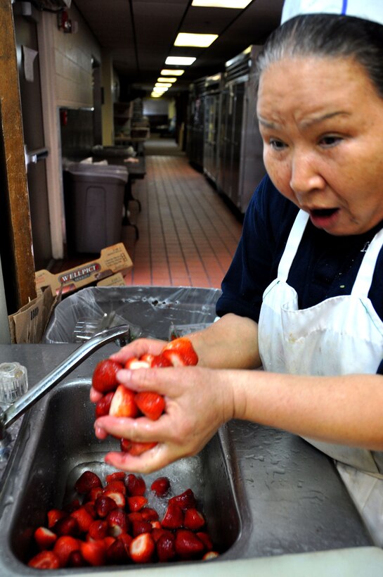 Nam Dodson washes strawberries in the Hap Arnold Club kitchen Oct. 16, 2010.  During unit training assembly weekends, the club staff prepares food for troop feeding and conference center events.  (U.S. Air Force photo/Linda Welz)