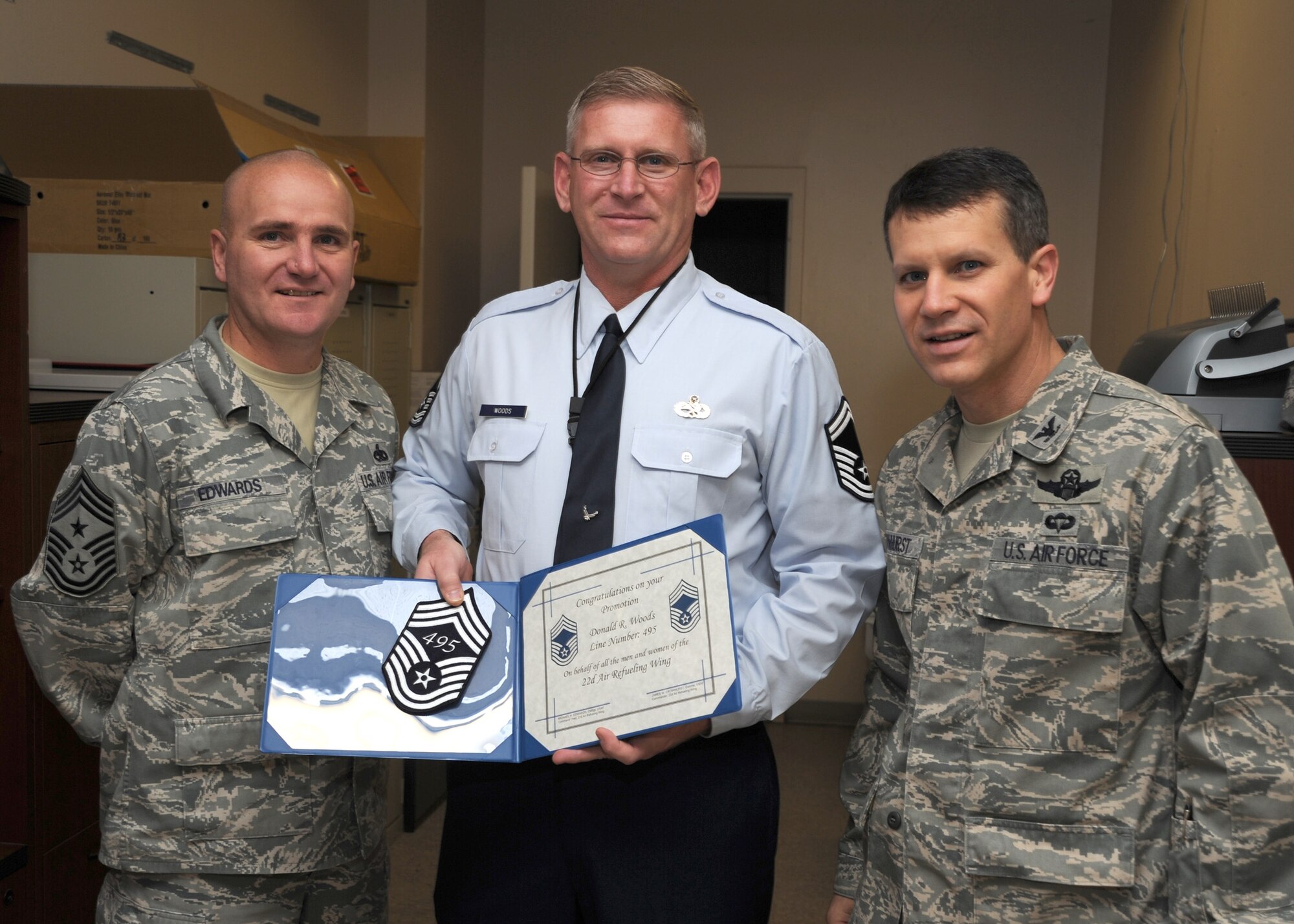 Chief Master Sgt. Michael Edwards, 22nd Air Refueling Wing command chief, left, and Col. Jamie Crowhurst, 22nd Air Refueling Wing commander, right, congratulate Senior Master Sgt. Donald Woods, 22nd Maintenance Group quality assurance superintendent, on his selection to chief master sergeant, Nov. 18, 2010, McConnell Air Force Base, Kan.  (U.S. Air Force photo/Staff Sgt. Dallas Edwards)