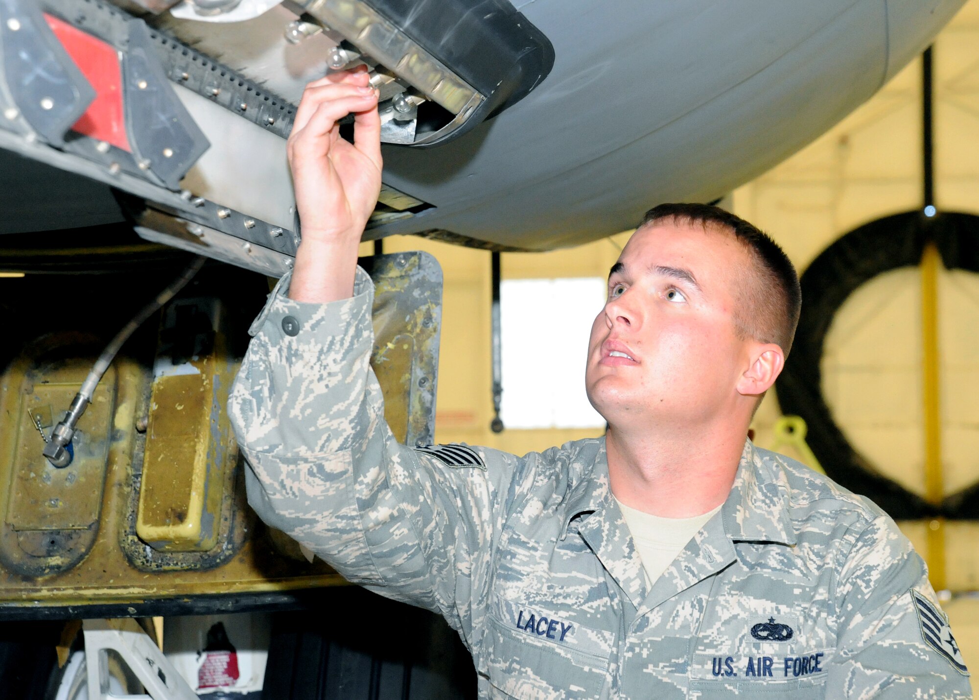 Staff Sgt. Joshua Lacey, 22nd Maintenance Squadron electro-environmental systems craftsman, tests the spring tension of the lights on the underside of a KC-135 Stratotanker for an isochronal inspection, Nov. 16, 2010, McConnell Air Force Base, Kan. ISO inspections are performed at required intervals to ensure the aircraft is mission ready. (U.S. Air Force photo/Airman 1st Class Katrina M. Brisbin)