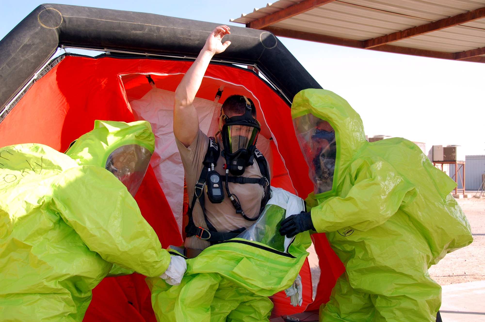 SOUTHWEST ASIA ? Firefighters from the 386th Expeditionary Civil Engineer Squadron complete decontamination procedures at an undisclosed air base here Nov. 12 as part of a training scenario to certify firefighters as hazardous-material response technicians. The Department of Defense certification program required base firefighters to don air-tight suits, identify unknown chemicals, follow detailed response procedures and execute a thorough decontamination process. (U.S. Air Force photo by Staff Sgt. Stefanie Torres)