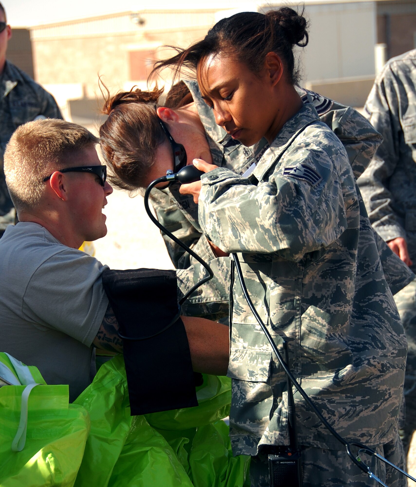 SOUTHWEST ASIA ? Staff Sgt. Sophia Parrish, a medical technician in the 386th Expeditionary Medical Group, takes blood pressure readings from firefighters Nov. 12 as they don protective chemical suits for a training scenario at an undisclosed air base here. Medical technicians also took vital signs after the scenario to ensure the health of participants. Sergeant Parrish is deployed from Wright Patterson Air Force Base, Ohio. (U.S. Air Force photo by Staff Sgt. Stefanie Torres)