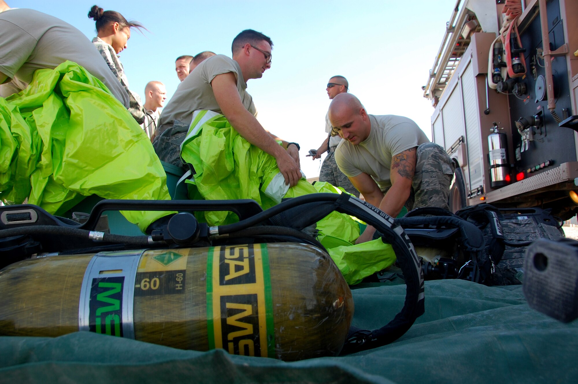 SOUTHWEST ASIA -- Firefighters from the 386th Expeditionary Civil Engineer Squadron don protective equipment Nov. 12 before participating in a chemical-response scenario at an undisclosed air base here. The exercise required base firefighters to wear air-tight suits, identify unknown chemicals, follow detailed response procedures and execute a thorough decontamination process. (U.S. Air Force photo by Staff Sgt. Stefanie Torres)