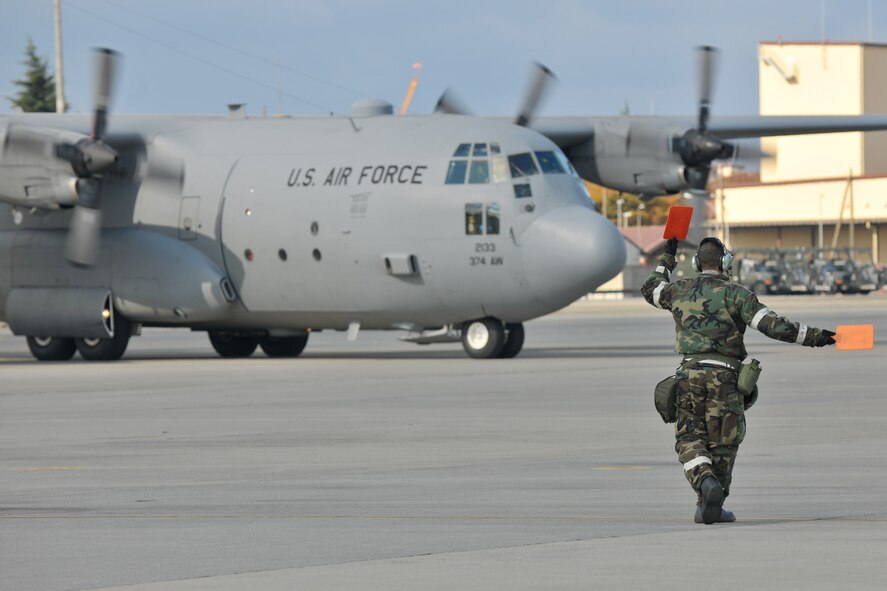 YOKOTA AIR BASE, Japan -- Tech. Sgt. Tony Mclaurin, 374th Aircraft Maintenance Squadron, marshalls a C-130 Hercules here Nov. 18 during the wing's Operational Readiness Exercise. (U.S. Air Force photo/Osakabe Yasuo)  