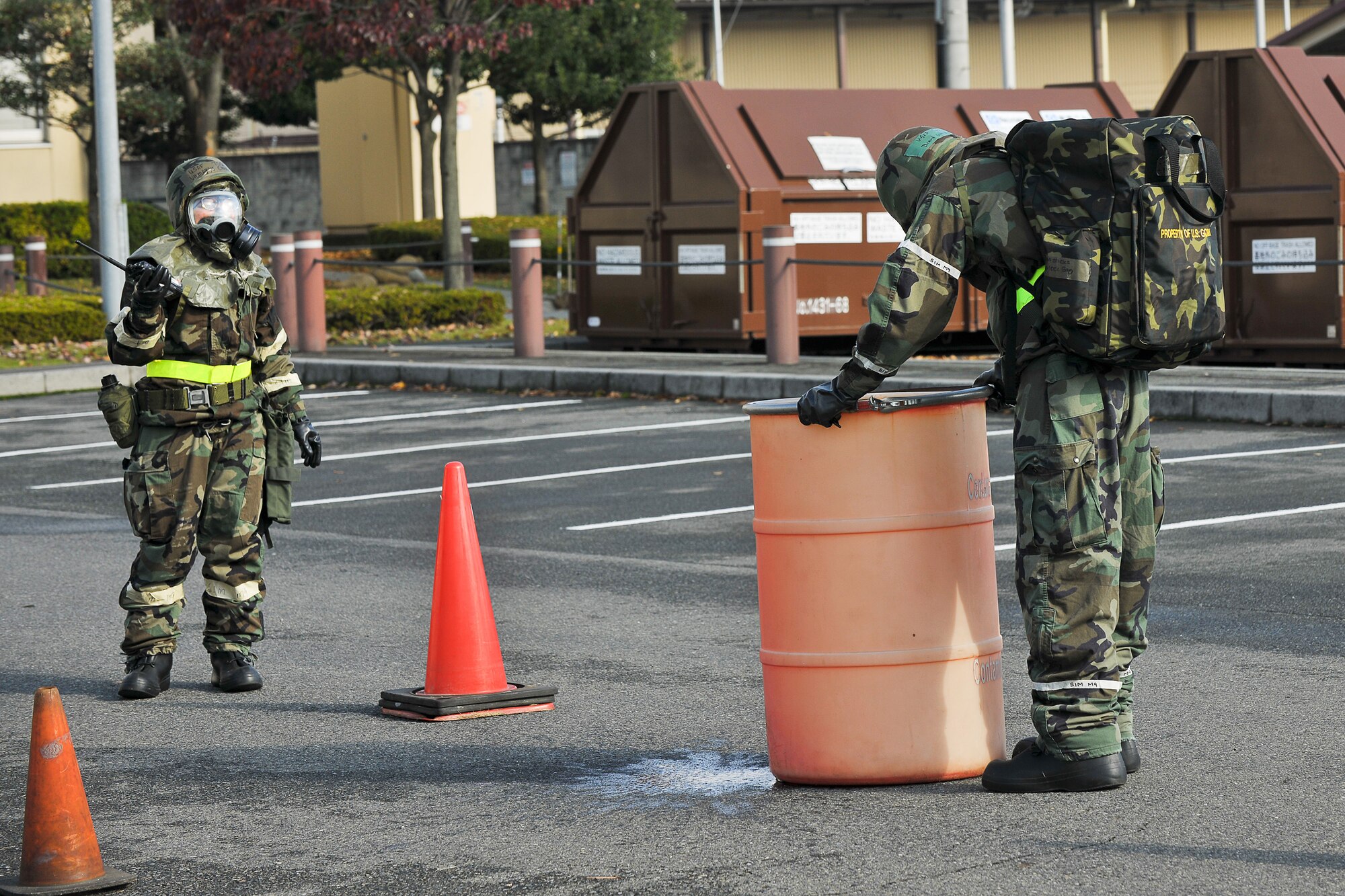 YOKOTA AIR BASE, Japan -- The 374th Airlift Wing, Wing Staff Agencies Post-Attack Reconnaissance Team demonstrates the proper way to dispose of simulated contaminated M8 papers at a Hazmat collection point here Nov. 18. (U.S. Air Force photo/Osakabe Yasuo)