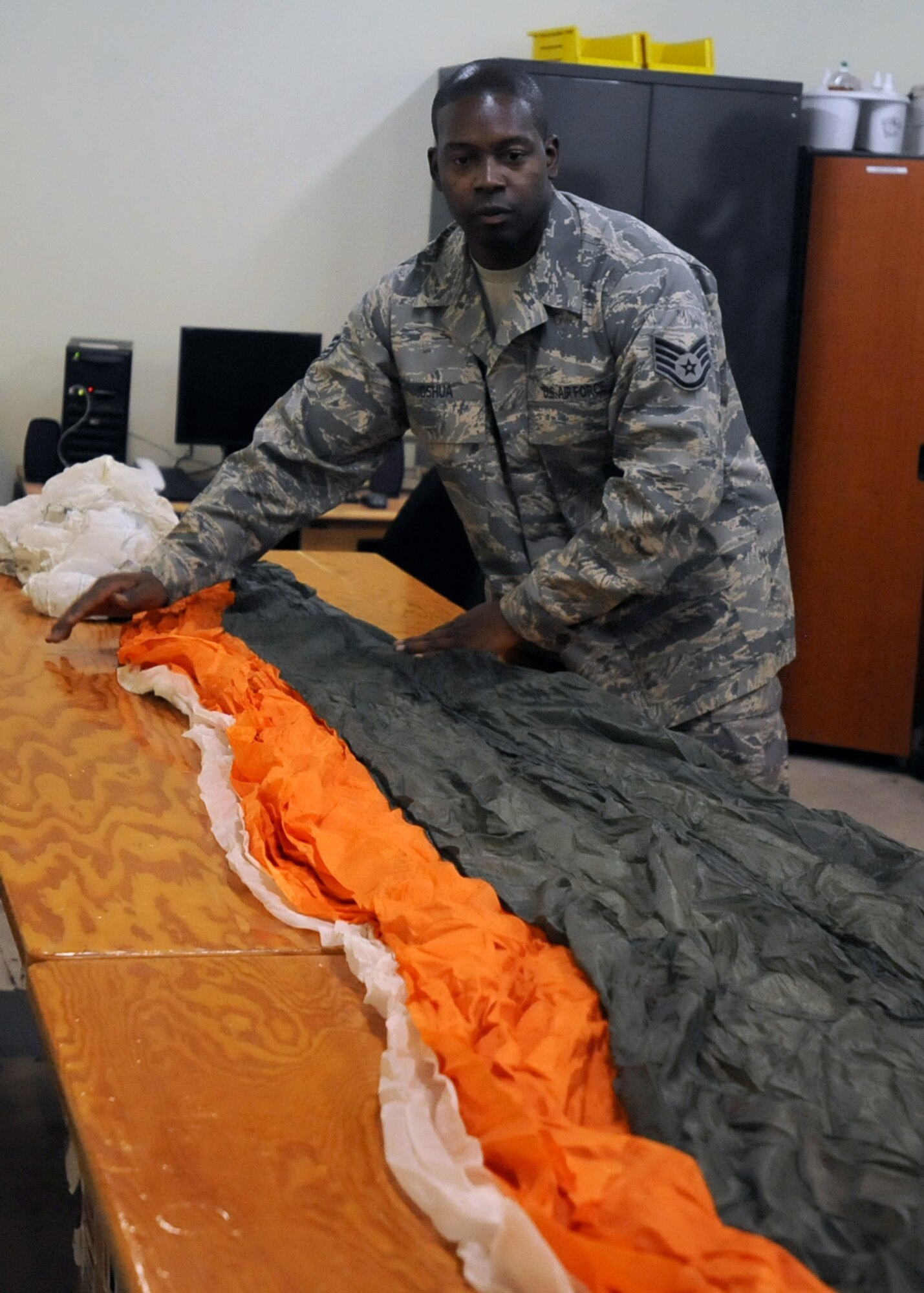 SOUTHWEST ASIA -- Staff Sgt. Venie Joshua, the NCO in charge of the 386th Expeditionary Operations Support Squadron's aircrew flight equipment shop, unpacks a parachute during an inspection Nov. 11, 2010, at an undisclosed air base here. Inspecting and packing parachutes can take up to four hours to complete. Sergeant Joshua is deployed from Dyess Air Force Base, Texas. (U.S. Air Force photo by Senior Airman Laura Turner)