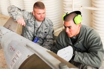 KUNSAN AIR BASE, Republic of Korea -- Senior Master Sgt. Benjamin Dorsey, Pacific Air Force Command Inspector General, listens to an 8th Fighter Wing maintainer as they review the proper procedures of safety checking munitions before loading them onto aircraft.  The wing participated in the Phase 1 operational readiness inspection Beverly Bearcat 10-06 that tested the wing's prepartion and mobilization from peacetime readiness into wartime posture. (U.S. Air Force photo/Staff Sgt. Jonathan Pomeroy)