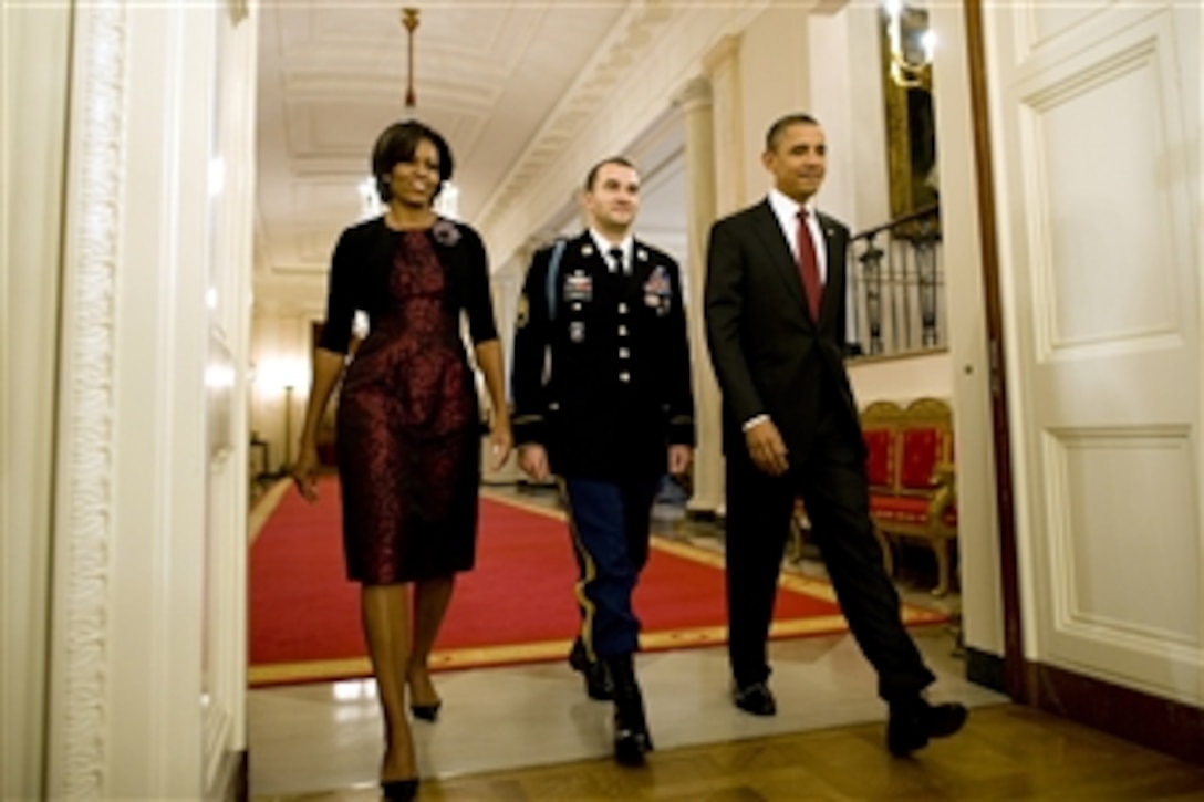 President Barack Obama (right), Staff Sgt. Salvatore Giunta and First Lady Michelle Obama enter the East Room of the White House to begin the Medal of Honor ceremony on Nov. 16, 2010.  Giunta, of Hiawatha, Iowa, is the first living veteran of the wars in Iraq and Afghanistan to receive the award.  