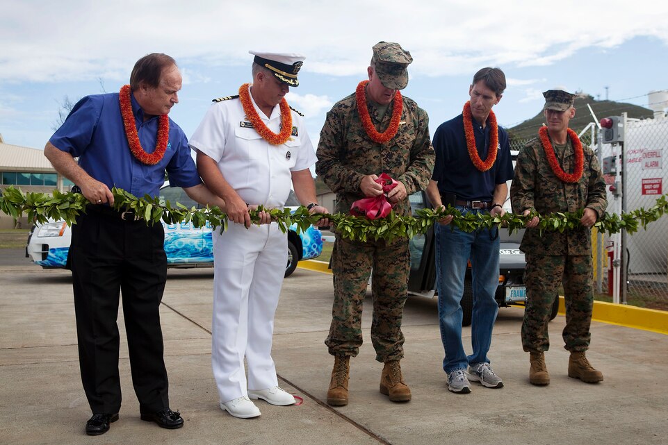 At center, Col. Robert D. Rice, commanding officer, Marine Corps Base Hawaii, and guests cut the ribbon for the base’s new E85 fueling station on Marine Corps Base Hawaii, Nov. 18, 2010. The fueling station was built as part of the continued expansion of alternative fuel vehicles on base. “As always, we are excited to lead the way in conservation,” Rice said. “The use of E85 alternative fuel along with 70 flex-fuel vehicles, three hybrids and 20 electric carts will drive MCBH’s carbon footprint lower and decrease our reliance on imported oil.”