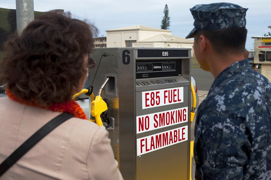 Petty Officer 2nd Class Rod Tiong, an aviation bulk fuel specialist with Headquarters Battalion, explains the benefits of alternative E85 ethanol fuel to a visitor at the ribbon cutting ceremony for the new E85 fueling station on Marine Corps Base Hawaii, Nov. 18, 2010. The E85 station is the first, fully operational one in the state of Hawaii for both military and civilian installations alike, said Larry Adams, director of sales and marketing, Aloha Petroleum. Its use supports Headquarters Marine Corps-mandated gasoline reduction goals and MCB Hawaii’s goal of reducing fossil fuel consumption 10 percent by next summer.