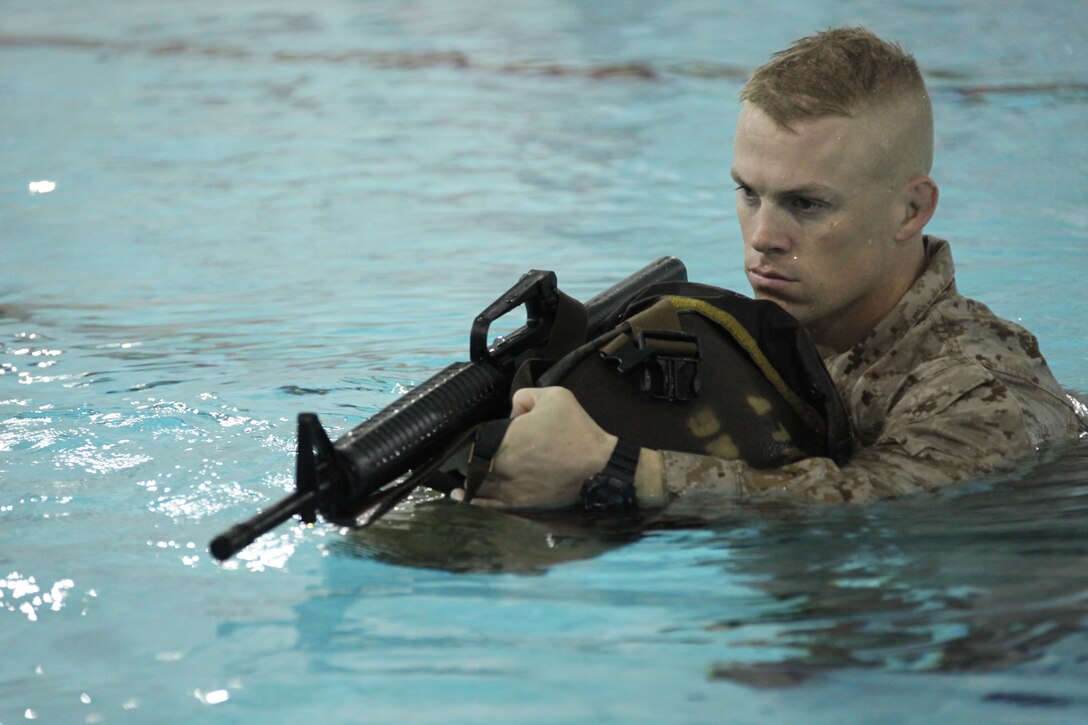 Gunnery Sgt. Michael Eason, an administration chief with Officer Candidate School, Marine Corps Base Quantico, Va., uses his assault pack as a floatation device during a demonstration for the new Marine Combat Water Survival training Nov. 19, 2010. The new MCWS has a renewed focus on familiarizing Marines with gear in the water at even the most basic level.