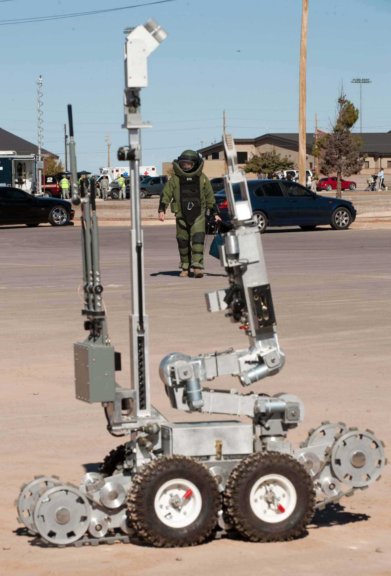 HOLLOMAN AIR FORCE BASE, N.M. -- Senior Airman James Howells walks toward a simulated vehicle-borne bomb in a bomb suit during an exercise inject Nov. 18, 2010. Airman Howells, an Explosive Ordinance Disposal technician with the 49th Civil Engineer Squadron, was called-in to perform reconnaissance of the vehicle after the utilization of the ANDROS HD-1 robot, pictured here. The exercise scenario called for members of the base to respond to a simulated terrorist threat from a group with access to the base. After performing reconnaissance, members of the EOD team effectively neutralized the simulated bomb. The anti-terrorism exercise also tested the base's ability to respond to changes in the Force Protection Condition in preparation for the upcoming Operational Readiness Inspection and possible real-world threats. (U.S. Air Force photo by Senior Airman Sondra Escutia/Released)