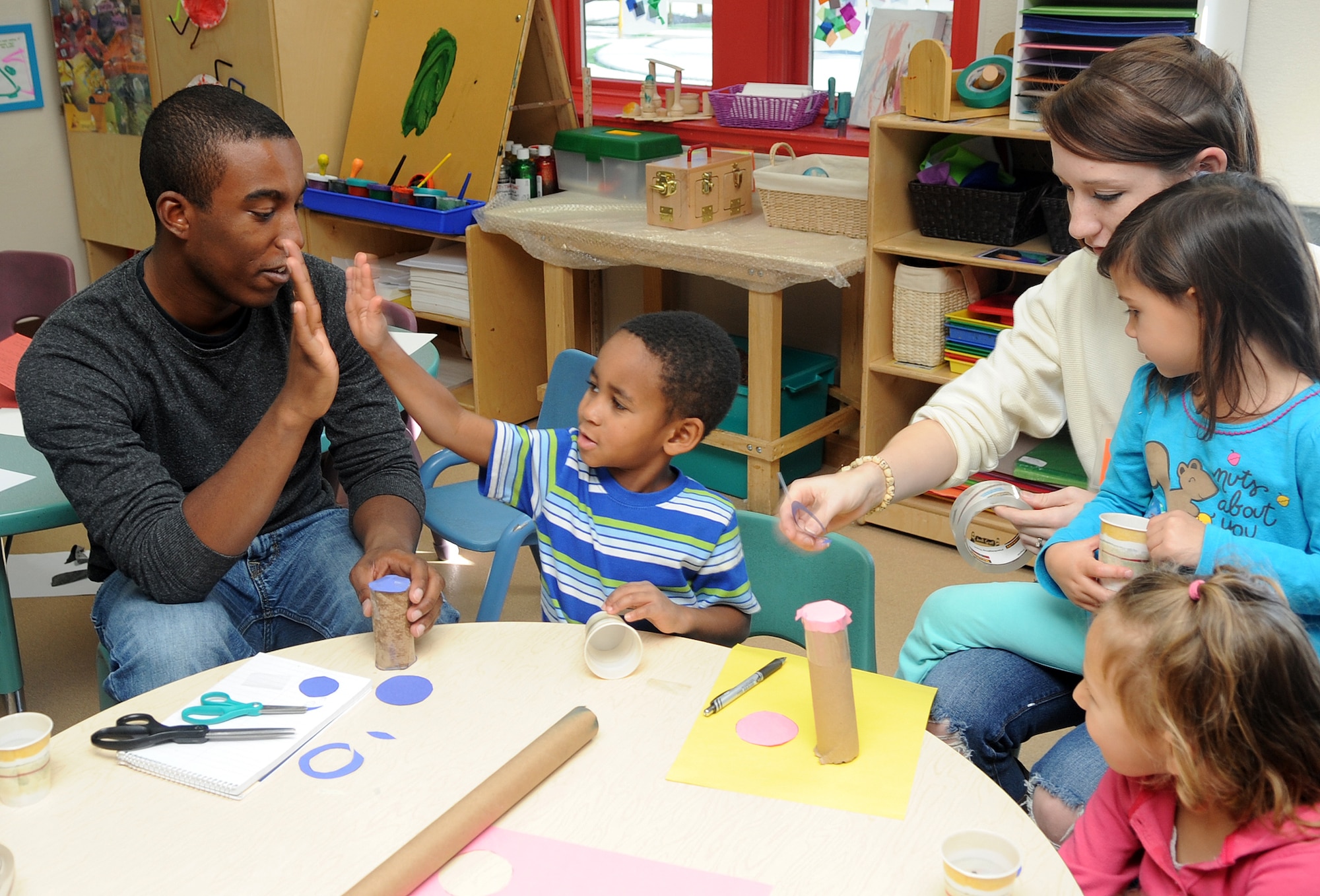 Buckley Air Force Base, Colo.-  Airman 1st Class Paul Labbe and Airman 1st Class Elisa Labbe helps a class make rain sticks for Native American Heritage month at the Child Development Center where volunteers from the Team Buckley spent the afternoon finger painting and making rain sticks. ( U.S. Air Force Photo by Airman First Class Marcy Glass )
