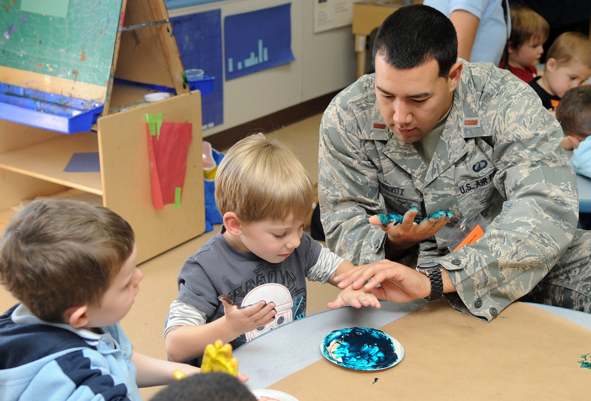Buckley Air Force Base, Colo.- 2nd Lt. Jared Rutkovitz goes "blue" finger painting with some of the children at the Child Development Center honoring Native American Heritage month where volunteers from the Team Buckley spent the afternoon finger painting and making rain sticks. ( U.S. Air Force Photo by Airman First Class Marcy Glass )