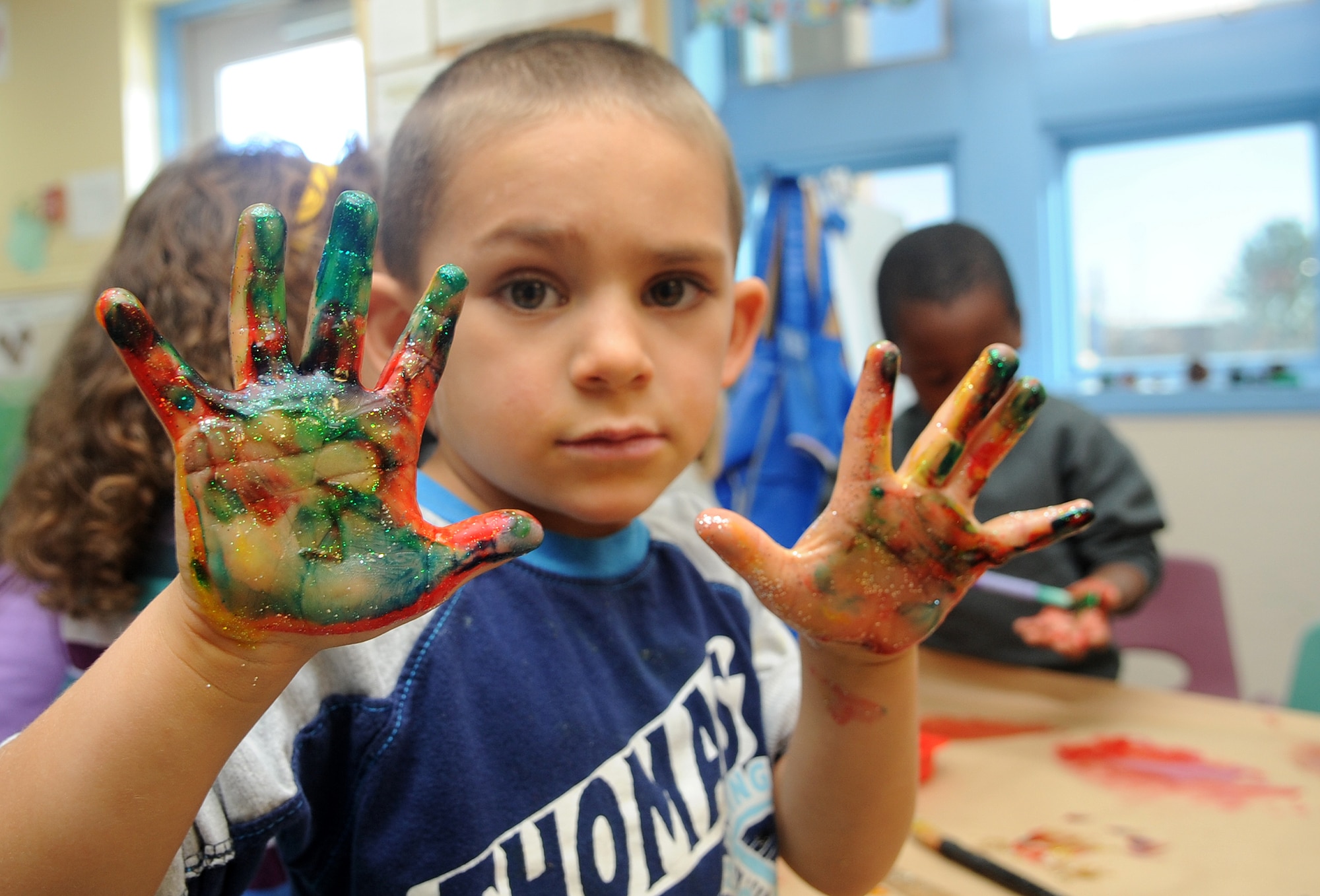 Buckley Air Force Base, Colo.- Daniel Rangel shows off his messy hands  at the Child Development Center where volunteers from the Team Buckley spent the afternoon finger painting and making rain sticks honoring Native American Heritage month. ( U.S. Air Force Photo by Airman First Class Marcy Glass )