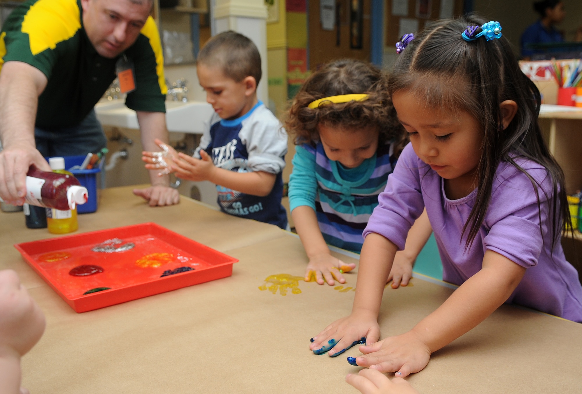 Buckley Air Force Base, Colo.- Children from the Child Development Center finger paint with volunteers from Team Buckley honoring Native American Heritage month. ( U.S. Air Force Photo by Airman First Class Marcy Glass )