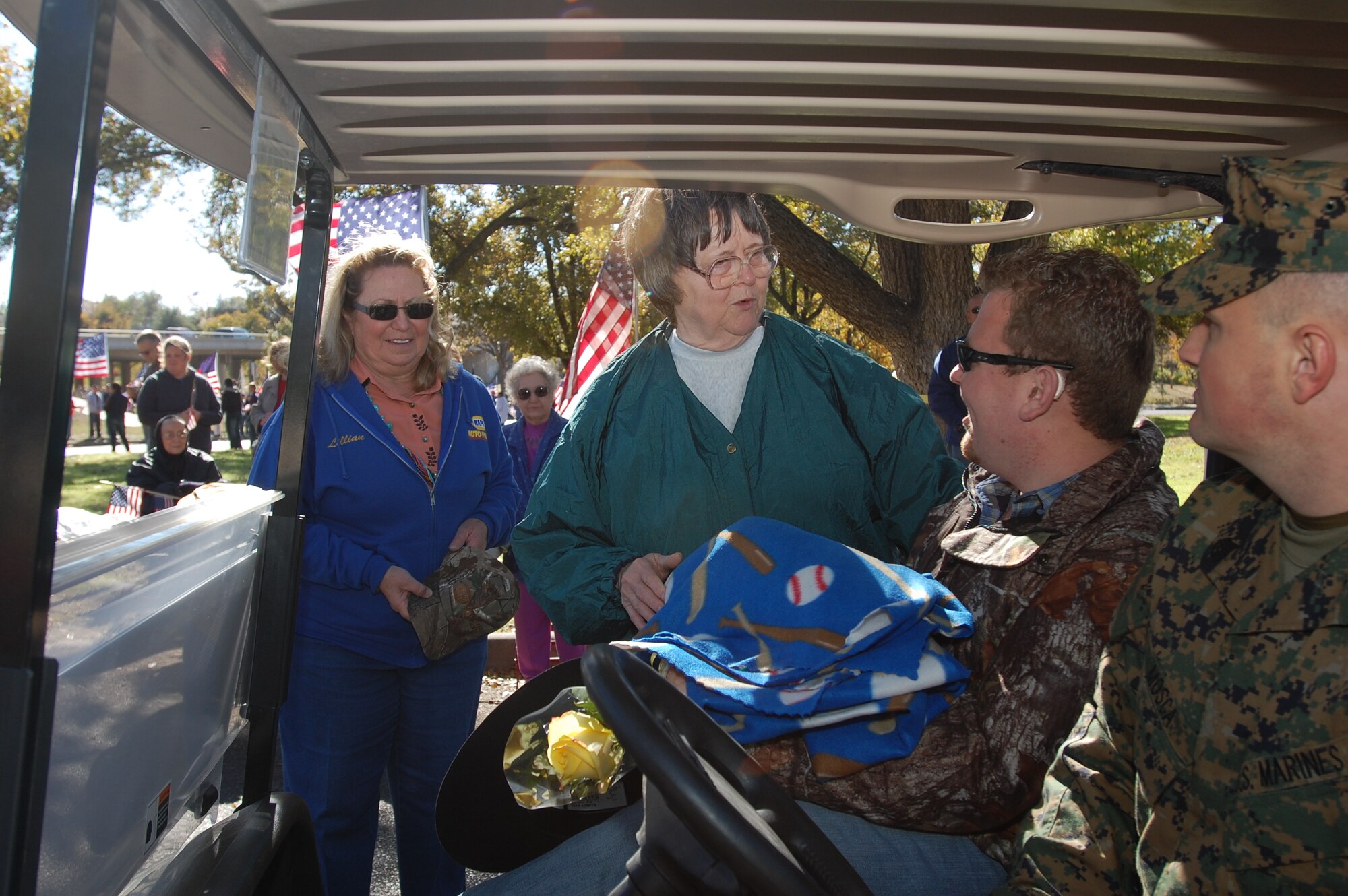 SAN ANGELO, Texas – San Angelo resident, Billie Wunderl (center), hands a blanket to Marine Cpl. Jason Harmon, during the Hunt for Heroes Parade Nov. 19. Twenty-five wounded warriors from all services participated in the parade. (U.S. Air Force photo/Staff Sgt. Heather Rodgers)