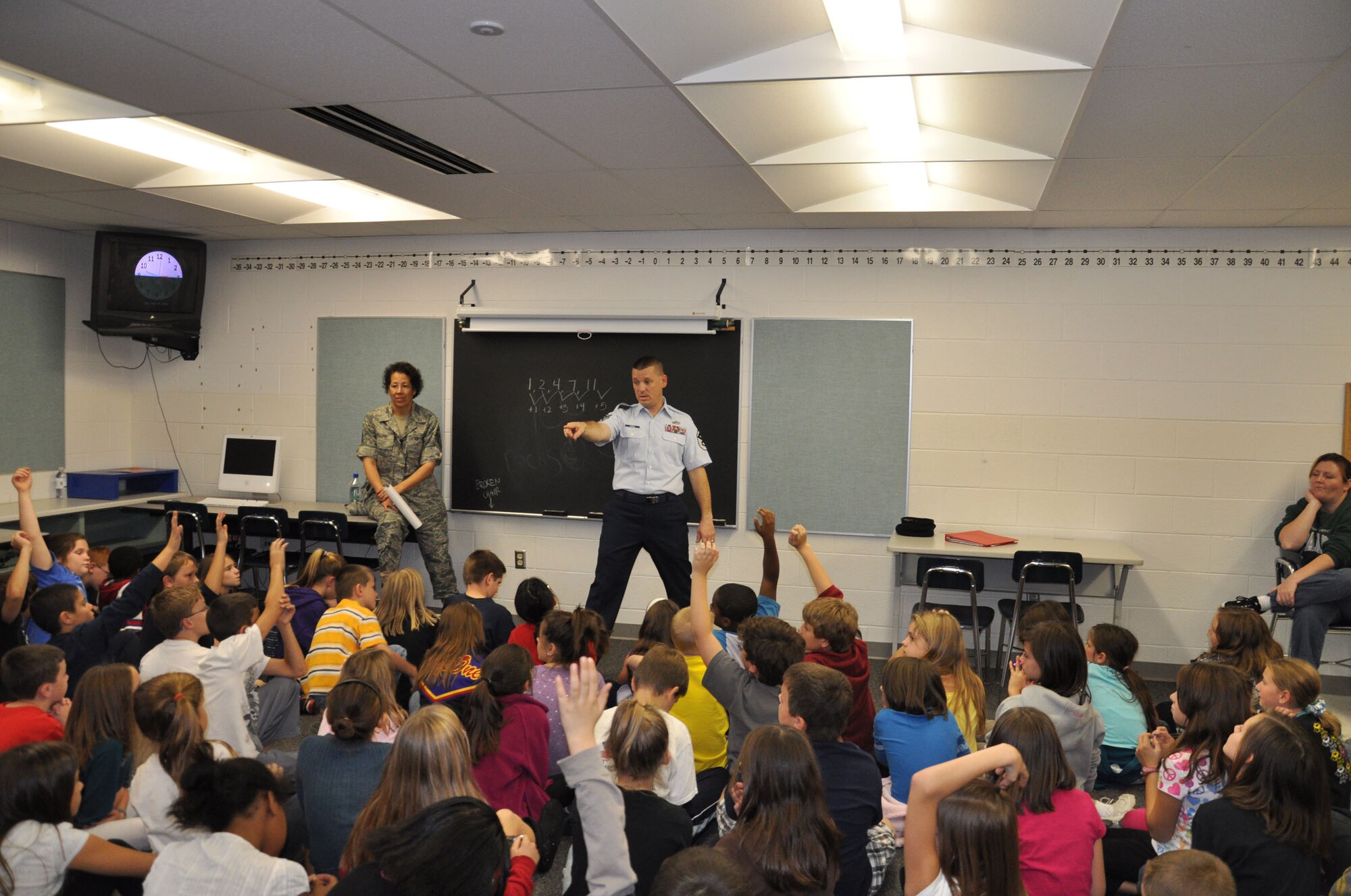 WRIGHT-PATTERSON AIR FORCE BASE, Ohio -  Master Sgt. Denise Williams, 445th Airlift first sergeant looks on as Master Sgt. John Koehl, 445th Security Forces Squadron first sergeant, makes a presentation about Veterans Day on Nov. 11 to a group of 4th and 5th graders at Alton Darby Creek Elementary School in Hilliard, Ohio. Sergeant Williams is a teacher at the elementary school. (U.S. Air Force photo/Senior Airman Matthew Cook) 
