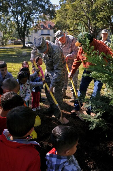 Col. Tim Fay, 2nd Bomb Wing commander, along with children from Barksdale Child Development Center participate in the Arbor Day Celebration by planting a Leyland Cypress tree in front of Chapel 1 on Barksdale Air Force Base, La., Nov. 17. Each year, a day is set aside in recognition of Arbor Day. BAFB has been recognized by TREE CITY USA for 20 consecutive years. (U.S. Air Force photo/Senior Airman La'Shanette V. Garrett)(RELEASED)