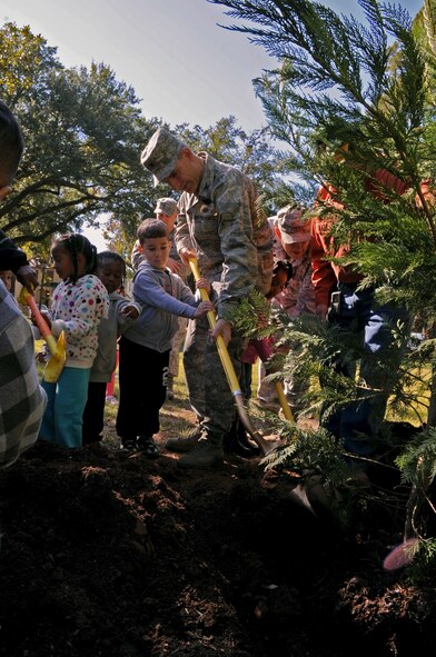 Col. Tim Fay, 2nd Bomb Wing commander and Kaden Taylor, 4, son of Tech. Sgt. Gerald Taylor, 2nd Communications Squadron NCO in charge of boundry protection, plant a Leyland Cypress tree in front of Chapel 1 on Barksdale Air Force Base, La., Nov. 17. Each year, a day is set aside in recognition of Arbor Day, an observance that encourages tree planting, care and preservation. The celebration, along with other requirements, qualifies BAFB to receive the Tree City USA Award. More than 15 children and staff members of the child development center came out for the celebration. (U.S. Air Force photo/Senior Airman La'Shanette V. Garrett)(RELEASED)