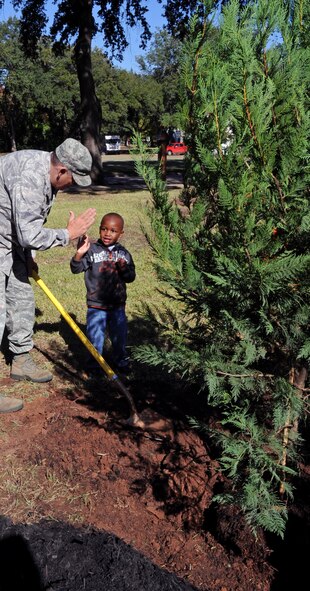 Chaplain (Lt. Col.) Robert O'Dell, 2nd Bomb Wing and Kamron Jackson, 3, son of Airman 1st Class Faquita Jackson, 2nd Force Support Squadron food specialist, give each other a high-five after planting a Leyland Cypress tree in front of Chapel 1 on Barksdale Air Force Base, La., Nov. 17. The tree was planted in observance of the Barksdale Arbor Day Celebration. Arbor Day is an observance that encourages tree planting and care. More than 700 trees were planted on Barksdale over the past 18 years. (U.S. Air Force photo/Senior Airman La'Shanette V. Garrett)(RELEASED)