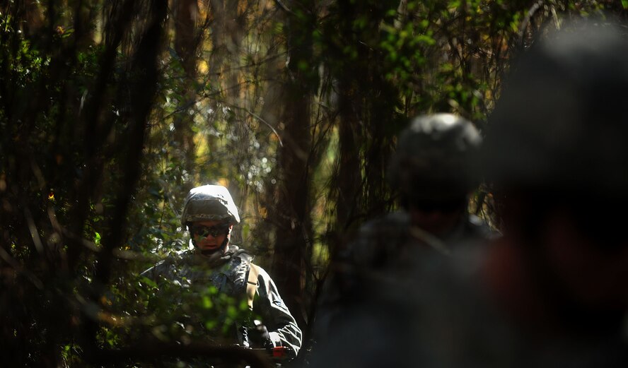 MOODY AIR FORCE BASE, Ga. -- Airman 1st Class Brian Aldred, 23rd Security Forces Squadron defender, walks through a beam of light while patrolling an area suspected of opposing forces during a Phase II Operational Readiness Exercise Nov. 17. The main goal of an ORE is to test the capabilities of Moody members in their assigned career fields while deployed. (U.S. Air Force photo/Airman 1st Class Joshua Green)(RELEASED)
