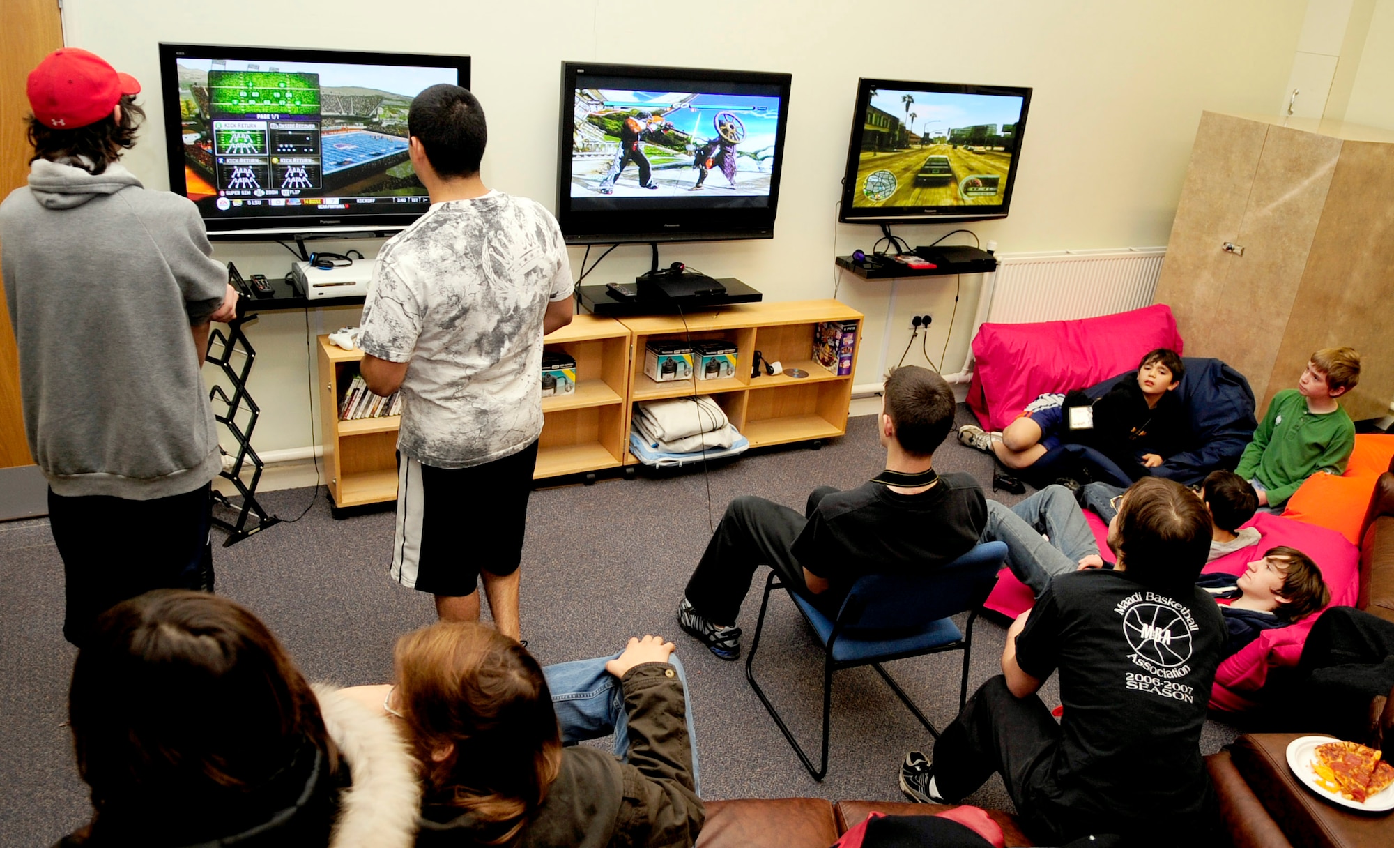 RAF MILDENHALL, England -- Team Mildenhall youths relax on couches at their new facility while eating pizza and playing video games during the teen center's grand opening. The new teen center will be open for use on Wednesdays from 6:30 - 8:30p.m. though the 100th Force Support Squadron Youth Center plans on expanding the hours in the future. (U.S. Air Force photo/Senior Airman Ethan Morgan)