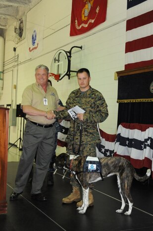 Rick Hairston presents "Jada" to Marine Sgt. Brian Jarrell at the Naval Consolidated Brig Charleston Nov. 18, 2010, on Joint Base Charleston-Weapons Station. Sergeant Jarrell was the first wounded veteran to be placed with a prisoner trained service dog through the Service Dog Program, which works in partnership with Carolina Canines for Service. The Carolina Canines for Service is a non-profit health and human services organization that trains service dogs for people with disabilities. Mr. Hairston is the President and CEO of Carolina Canines for Service and Sergeant Jarrell is assigned to the Wounded Warrior Battalion-East aboard Marine Corps Base Camp Lejeune, N.C.(U.S. Air Force photo/James M. Bowman)
