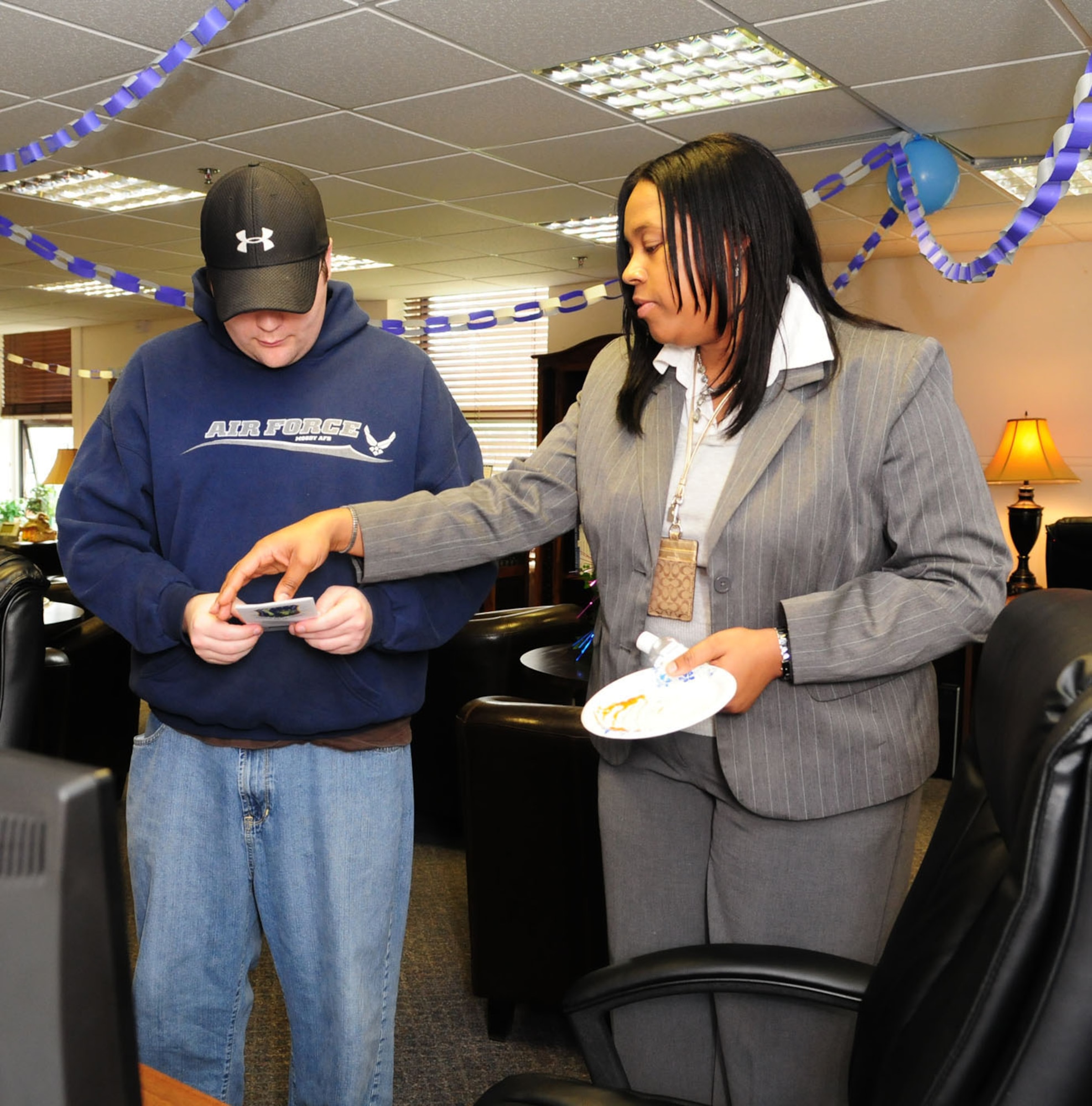 RAF MILDENHALL, England -- Angela Cottman (right), 100th Force Support Squadron Airman and Familiy Readiness Center, talks to James Holley, RAF Mildenhall family member, about job opportunities during the A&FRC open house here Nov. 18. As part of Month of the Military Family, the A&FRC held the event to show members what services are offered to active duty and family members. (U.S. Air Force photo/Karen Abeyasekere)