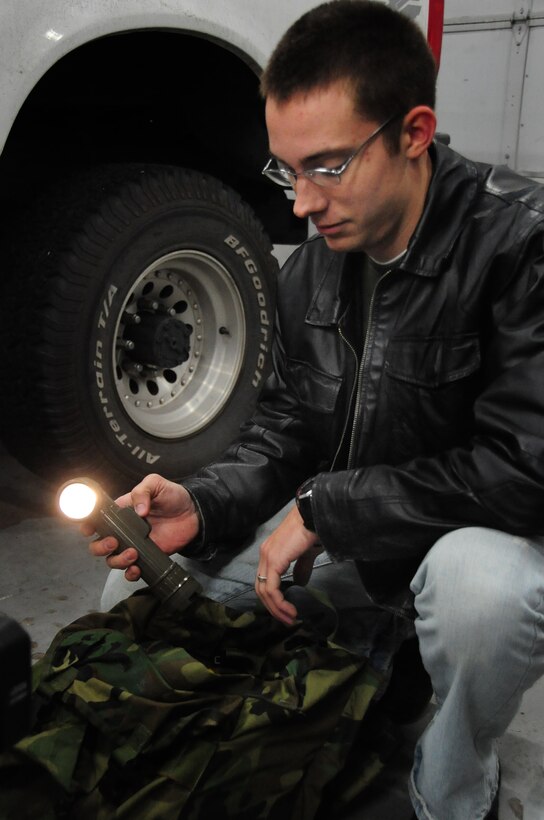 ELLSWORTH AIR FORCE BASE, S.D. - Airman 1st Class Eli Goff, 28th Operations Group air traffic controller, checks a flashlight in his vehicle safety kit in preparation for the winter season, Nov. 17.  Airmen are encouraged to have emergency items on hand in their vehicles, such as first-aid kits, water, flashlights and extra blankets. (U.S. Air Force photo/Senior Airman Anthony Sanchelli)
