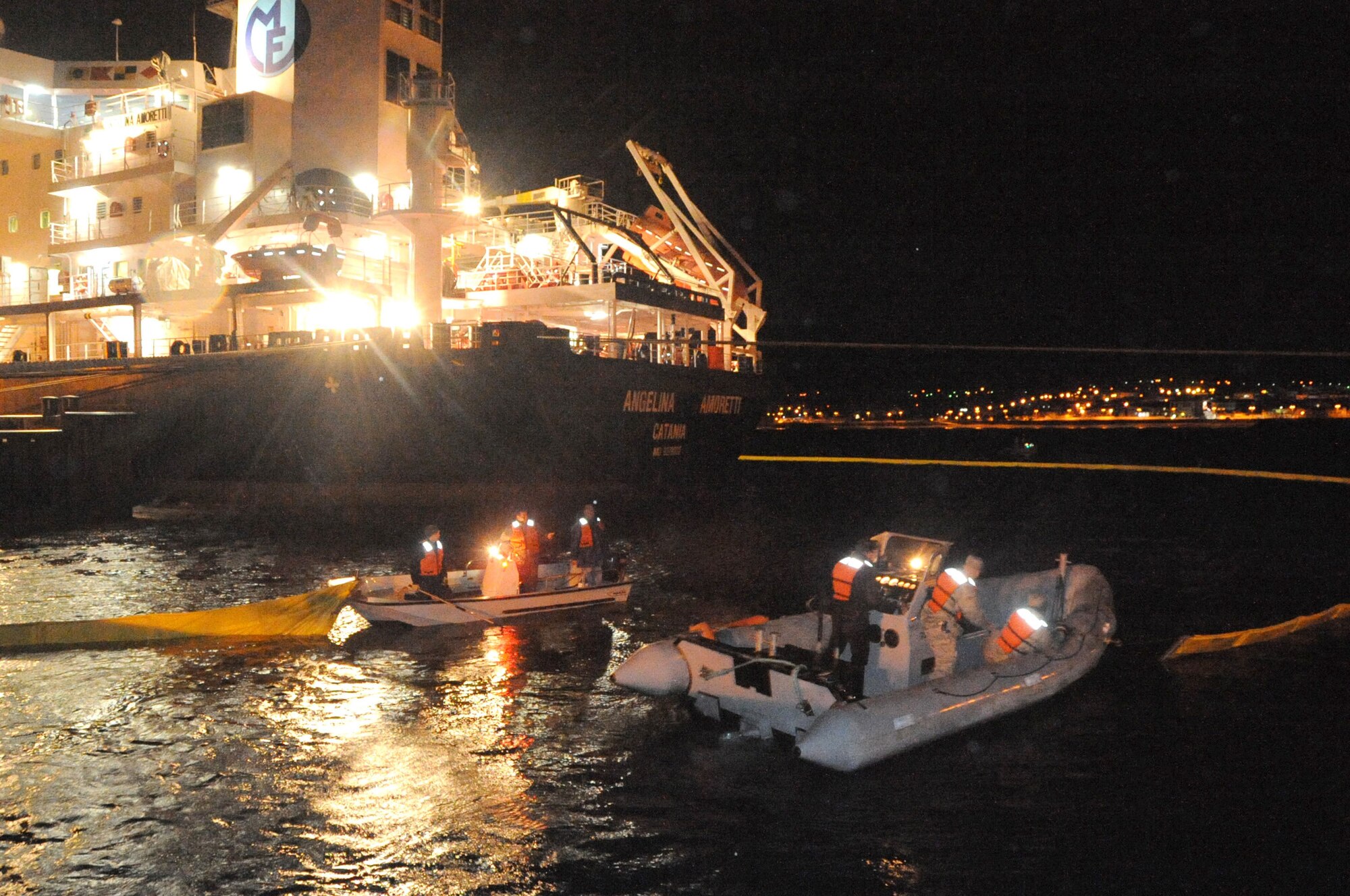 Airmen of 65th Civil Engineer Squadron work with their Portuguese partners to secure a boom around an oil vessel in Praia, Terceira Island, Nov. 17, 2010.  A boom is placed around oil vessels as a safety measure in case of a fuel leak during transfer.  (U.S. Air Force photo by Tech. Sgt. Chyrece Campbell)
