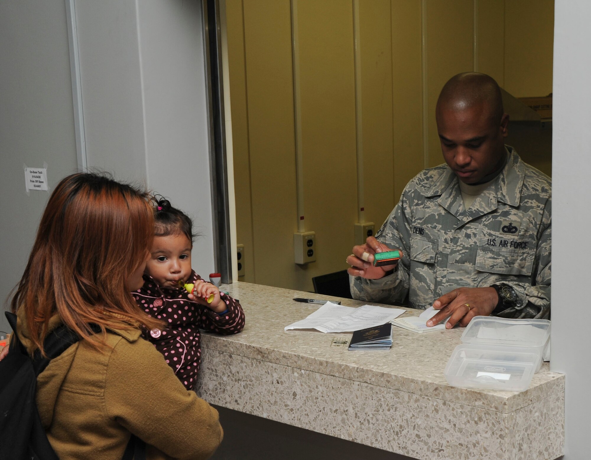 U.S. Air Force Staff Sgt Jean-Joseph Denis, right, 35th Security Forces Squadron, processes a member of the Misawa community for out-bound travel from Misawa Air Base, Japan, Nov. 15, 2010. Once assigned a seat aboard the plane, passengers process through customs to depart the country. (U.S. Air Force photo by Tech. Sgt. Russell McBride/Released)