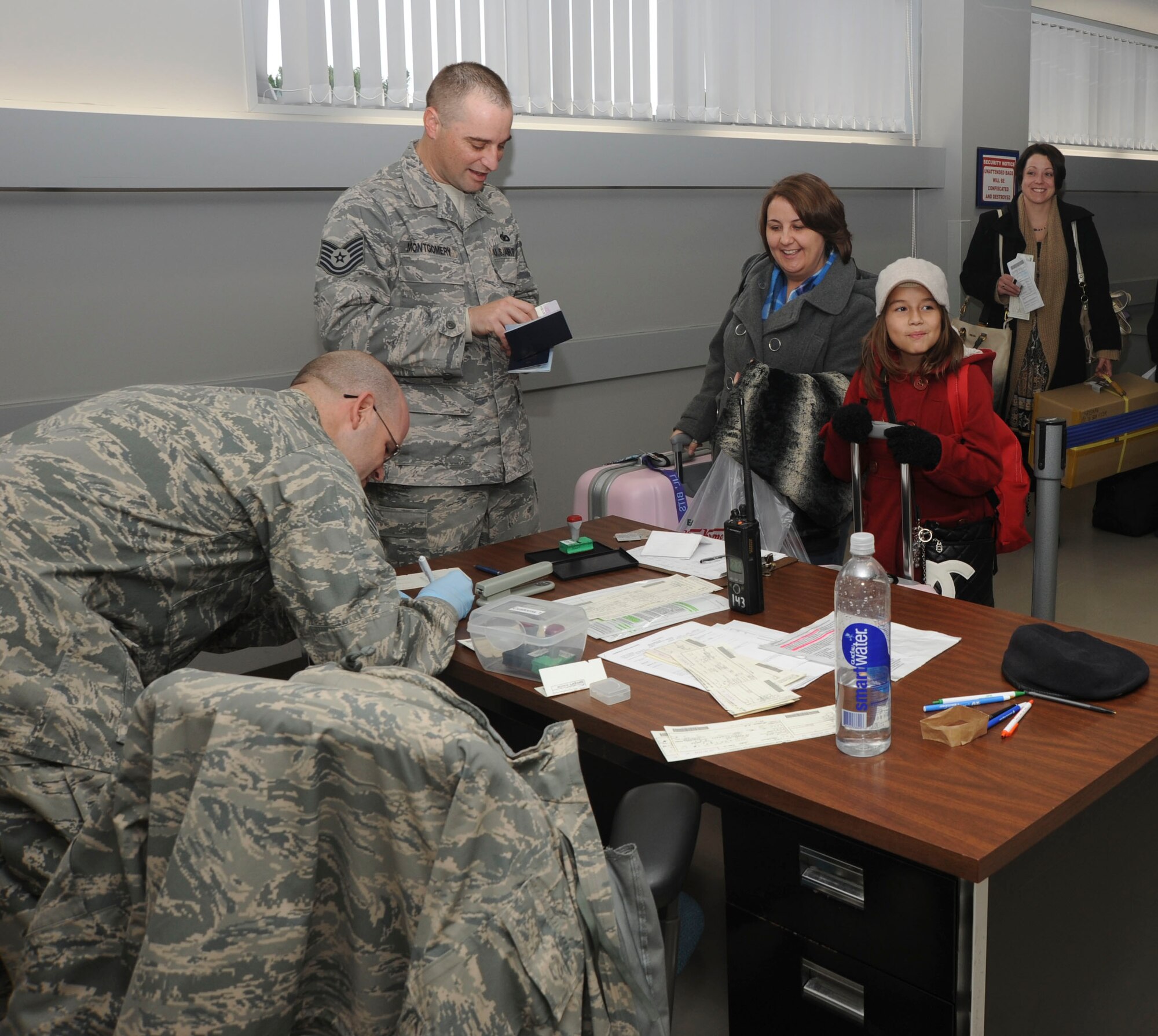 U.S. Air Force Staff Sgt Ross List, left, 35th Security Forces Squadron, NCO in charge of customs and confinement, and Tech. Sgt. Michael Montgomery, center, 35th SFS, NCO in charge of vehicle search, process passengers through customs at Misawa Air Base, Japan, Nov. 15, 2010. Passengers coming from Korea process through customs to complete Government of Japan Disembarkation forms. (U.S. Air Force photo by Tech. Sgt. Russell McBride/Released)