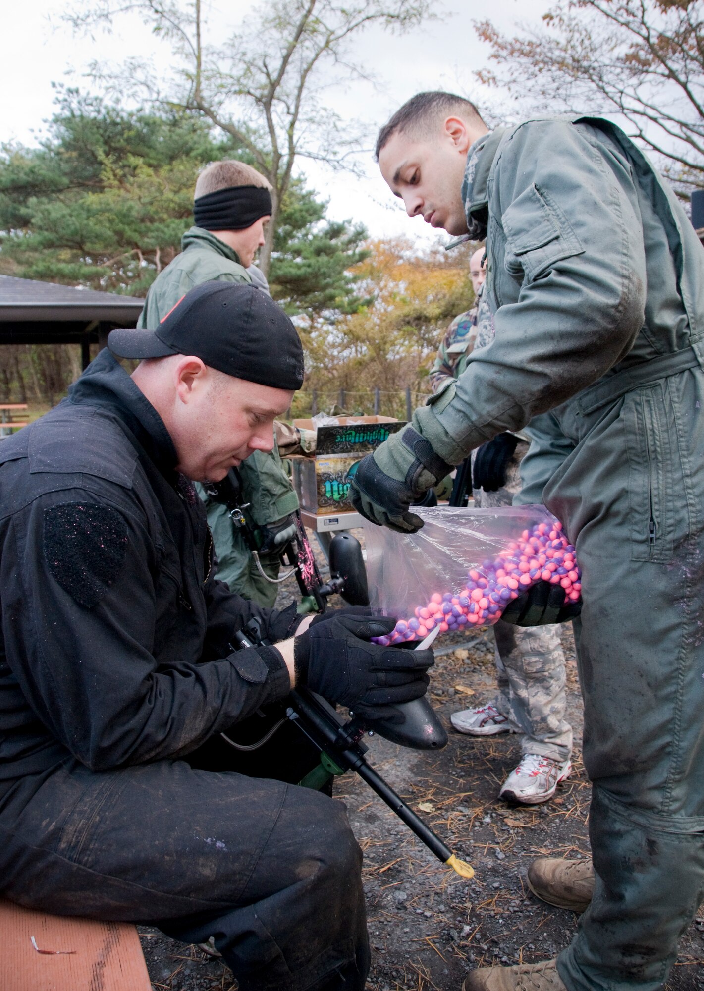 Senior Airman William Holliday, 35th Civil Engineer Squadron Explosive Ordnance Disposal technician, pours paintball rounds into a paintball gun for fellow EOD technician Tech. Sgt. Rory Stark, Nov. 10, 2010, during an annual EOD Safety Stand-down day at Misawa Air Base, Japan. The EOD flight and their family members spent a portion of the day reconnecting and taking a step back from the normally busy work day. (U.S. Air Force photo by Senior Airman Jessica Lockoski)